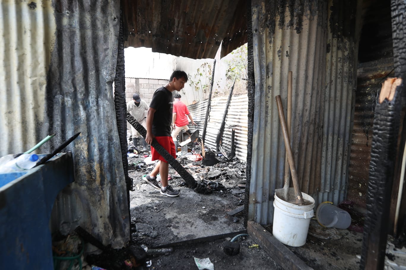 Vecinos de Ciudad Peronia apoyan en la limpieza del lugar donde el lunes 6 de marzo se registró un incendio que se cobró la vida de un niño de 10 años. (Foto Prensa Libre: Roberto López)