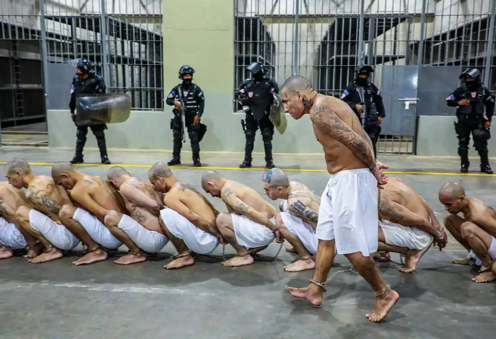 Pandilleros durante un traslado masivo a la nueva cárcel en El Salvador. (Foto Prensa Libre: AFP)