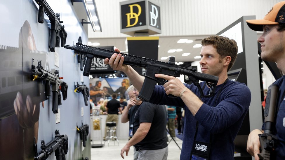 Un miembro de la NRA posa con un arma del tipo AR-15 durante la conferencia anual en Indianápolis, Indiana, celebrada este fin de semana.
