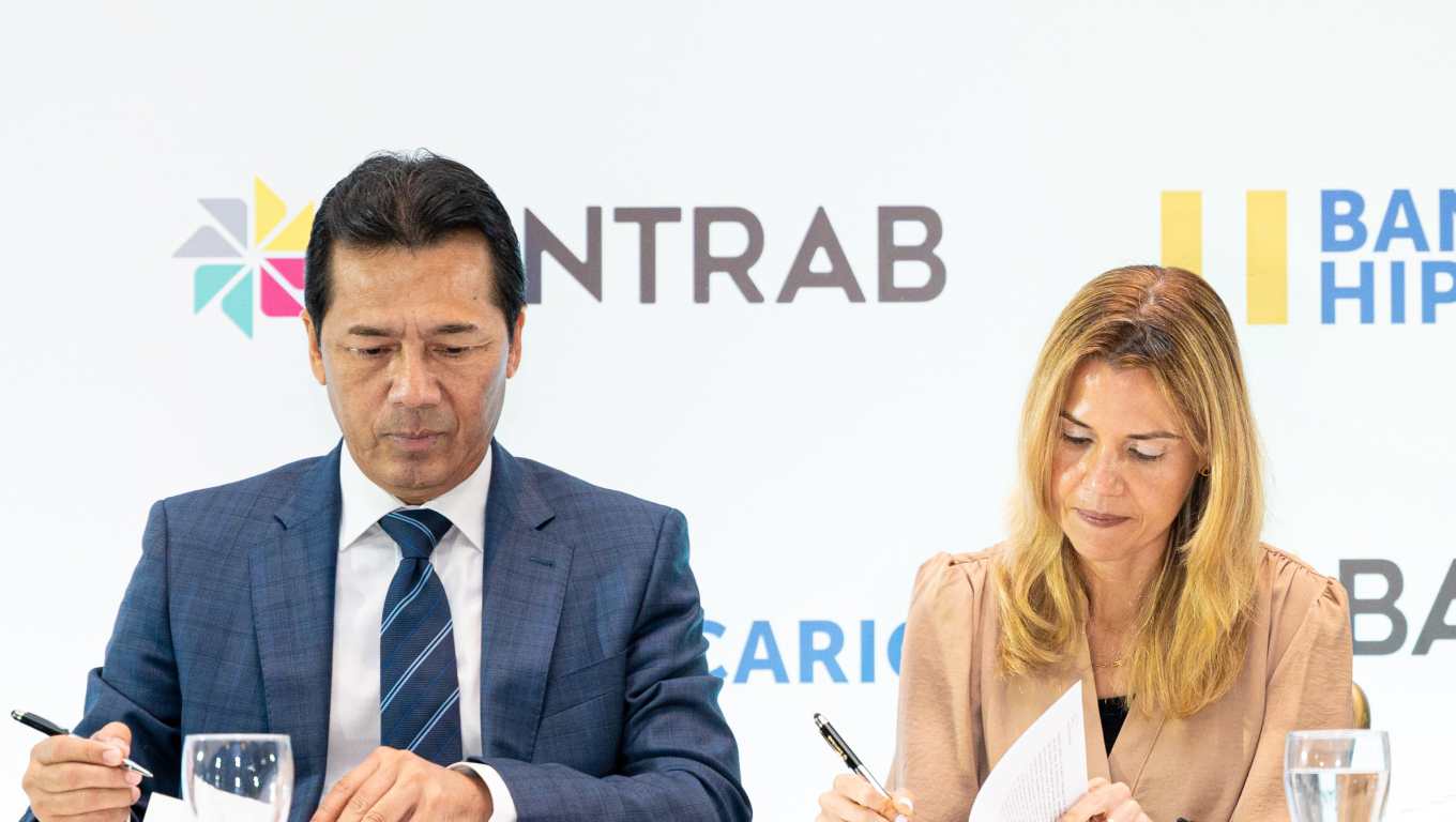 Momento en que Jorge Mondal, presidente de la Junta Directiva de Bantrab; y Celina María Padilla, presidenta del Banco Hipotecario de El Salvador, firman en convenio. Foto Prensa Libre: Cortesía