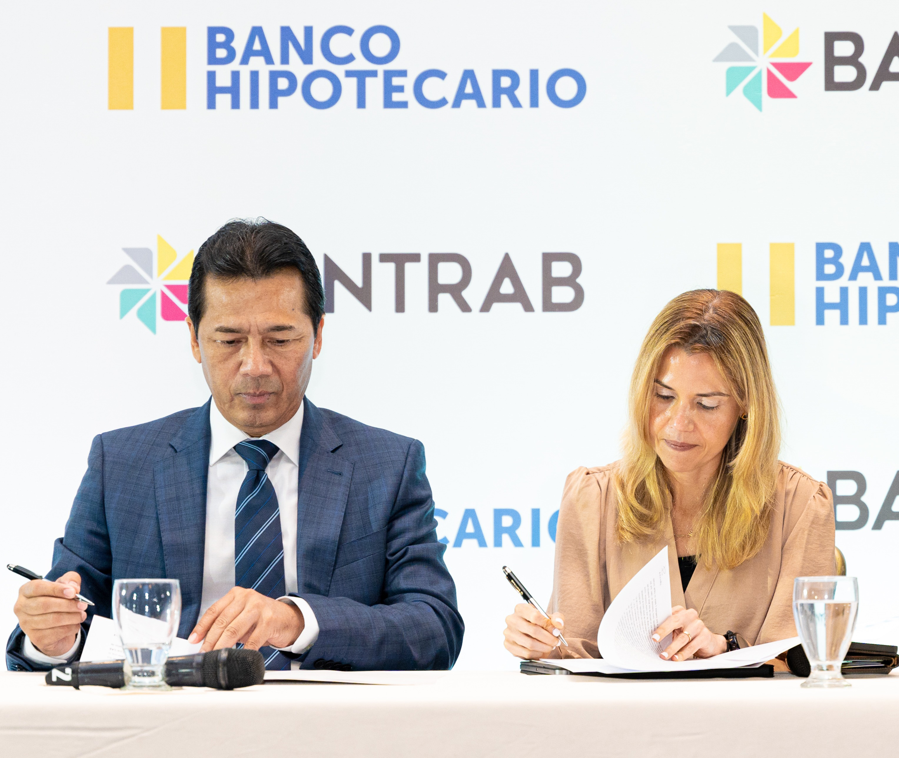 Momento en que Jorge Mondal, presidente de la Junta Directiva de Bantrab; y Celina María Padilla, presidenta del Banco Hipotecario de El Salvador, firman en convenio. Foto Prensa Libre: Cortesía