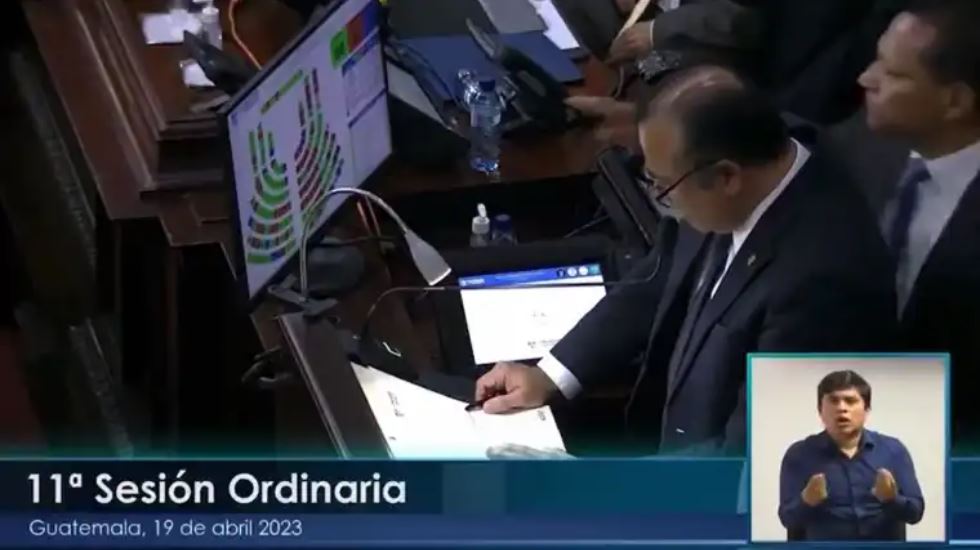 Momento en el que el diputado Armando Castillo, arriba a la derecha, le tira el micrófono al congresista Aníbal Estuardo Rojas Espino. (Foto Prensa Libre: Captura de video Congreso de la República)
