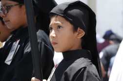 Un niño espera a que la procesión del Señor Sepultado de Santo Domingo llegue a la esquina donde él se encuentra, para llevarlo en hombros. (Foto Prensa Libre: Álvaro González)