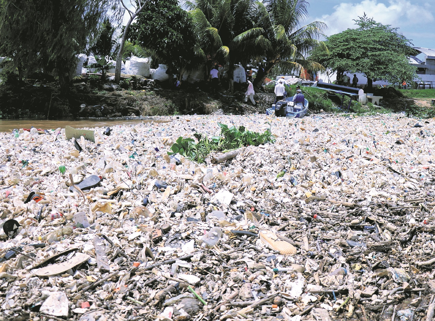 Trabajadores tratan de recolectar desechos sólidos retenidos por una biobarda artesanal en la comunidad El Quetzalito,  Puerto Barrios, Izabal, a pocos kilómetros de la desembocadura del río Motagua. (Foto Prensa Libre: Hemeroteca PL)