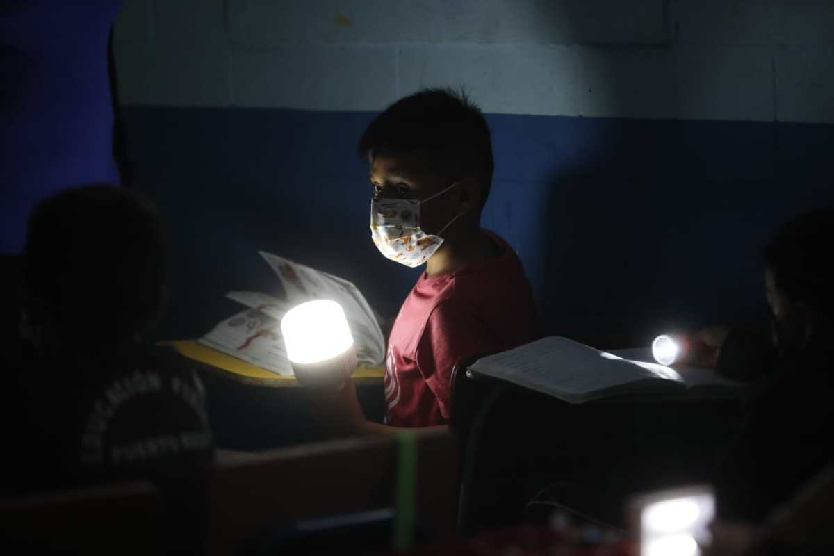 “Llega la hora en la que no se ve nada”: imágenes muestran cómo estudiantes usan linternas para recibir clases por falta de luz en escuela de zona 18
