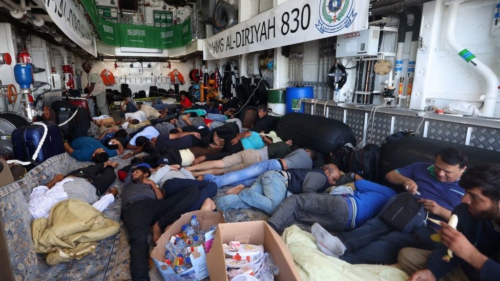 Evacuados descansan a bordo de un buque naval saudita mientras viaja de Puerto Sudán a Yeda.