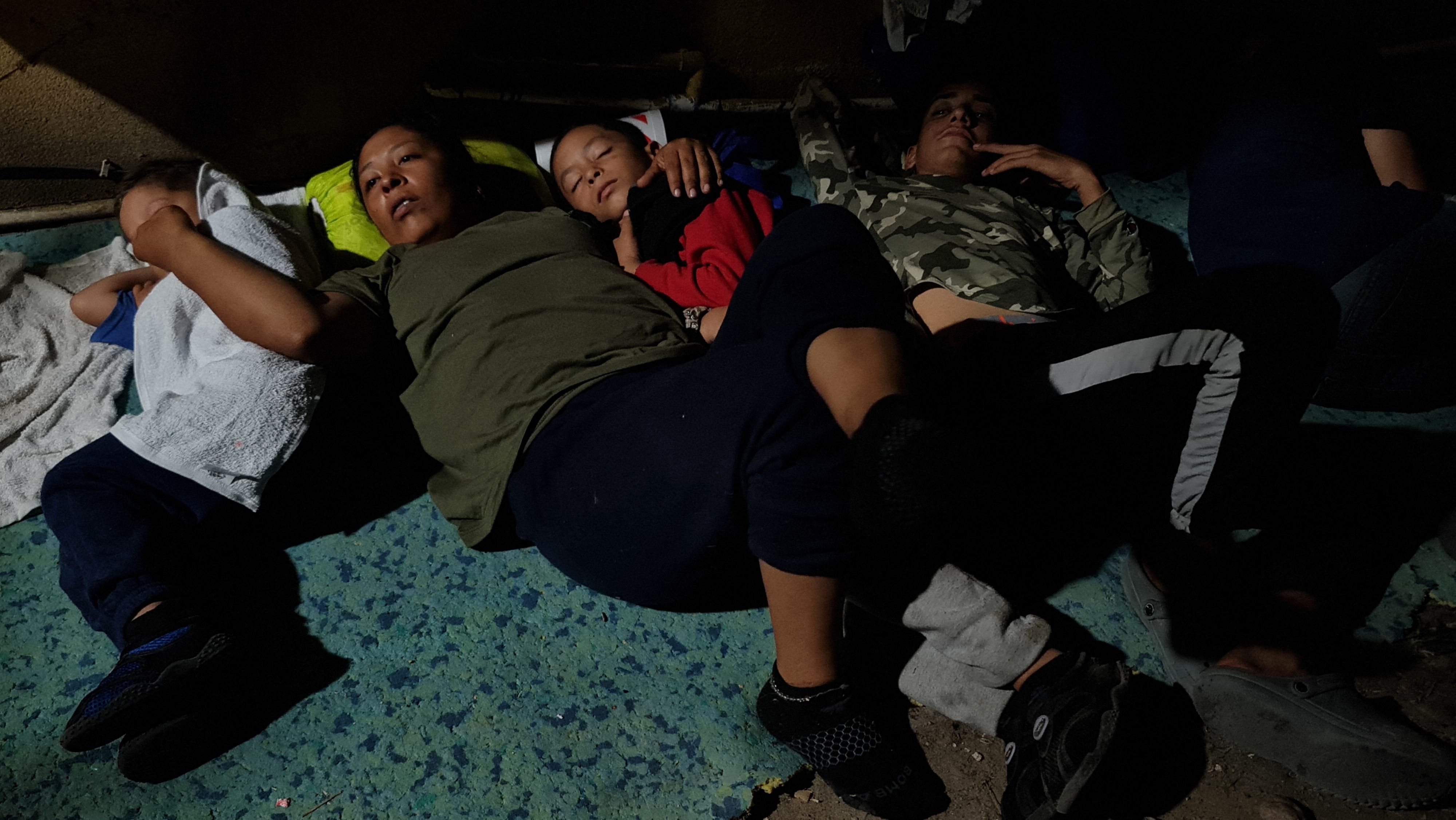 Dasling Sanchez, 28, and sus dos hijos  duermen luego de recibir pizza en una iglesia local de en el centro de Brownsville, Texas.  Migrantes han acelerado el cruce a EE. UU. y han convertido esa ciudad en un dormitorio. (Foto Prensa Libre: AFP)