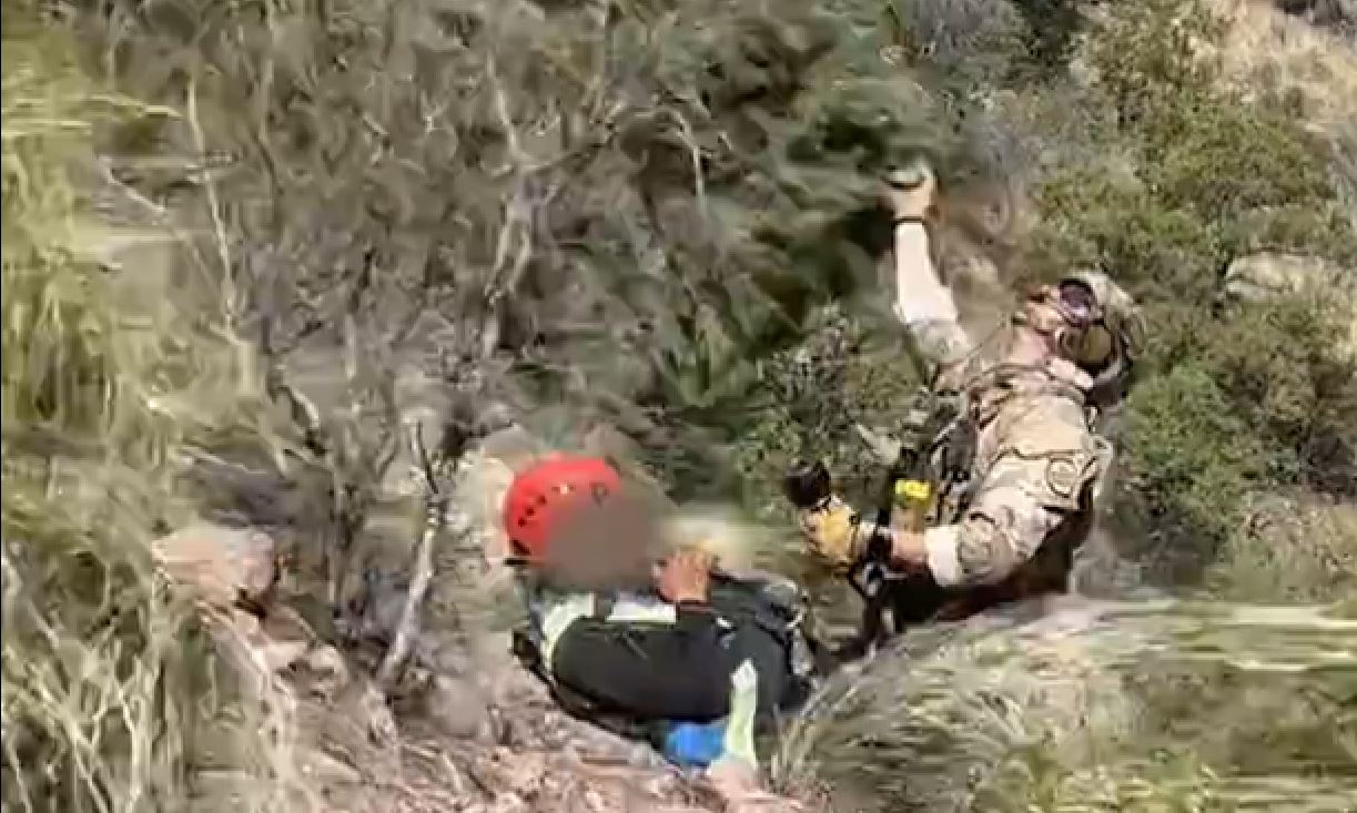 Un agente de la Patrulla Fronteriza de EE. UU. asegura a un joven guatemalteco para llevarlo a un helicóptero, luego de haber silo localizado en un desierto de Arizona. (Foto Prensa Libre: captura de pantalla del video de @USBPChiefTCA)