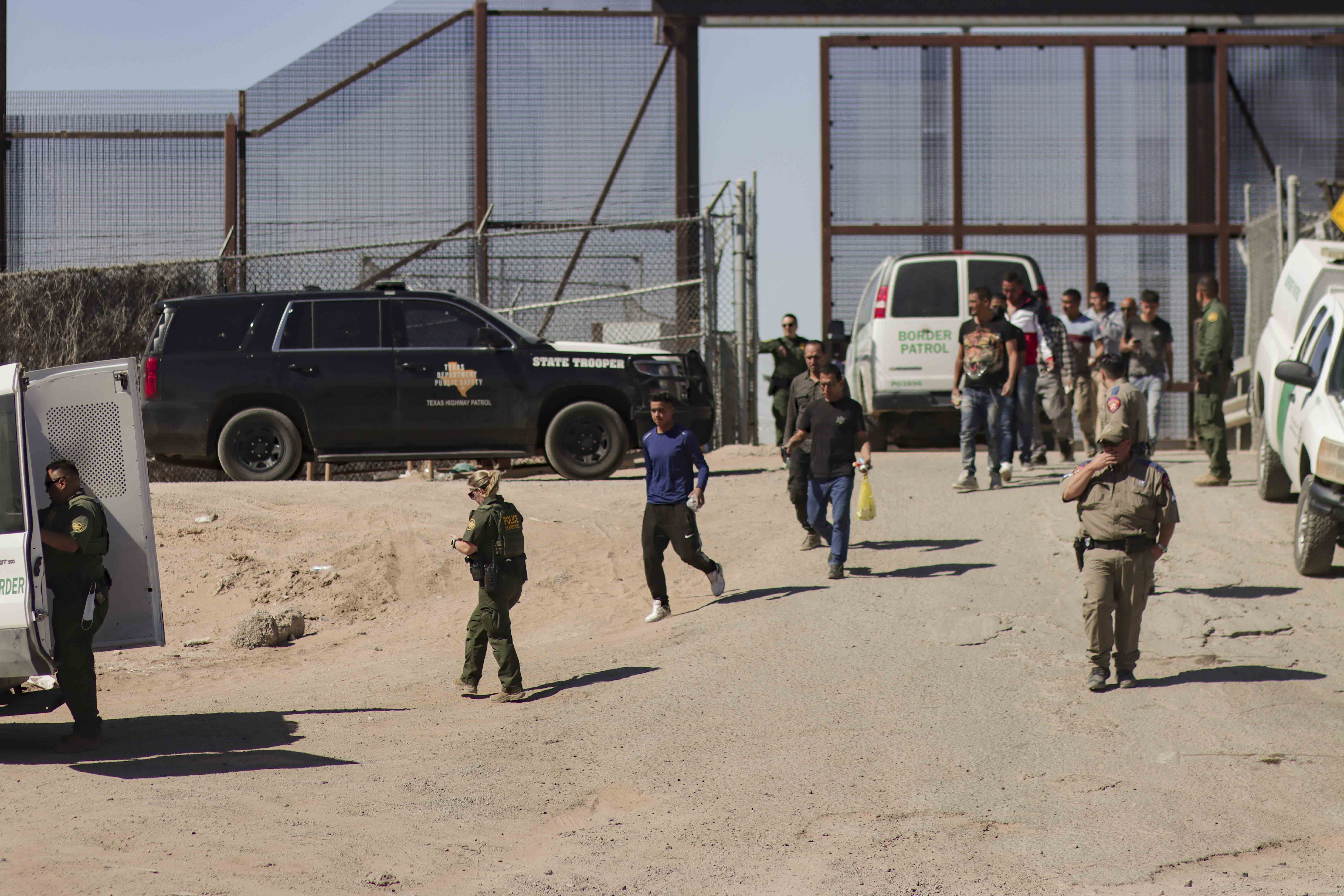 Migrantes detenidos son llevados por miembros de la Patrulla Fronteriza estadounidense a un vehículo, junto al muro fronterizo en El Paso, Texas. (Foto Prensa Libre: EFE)