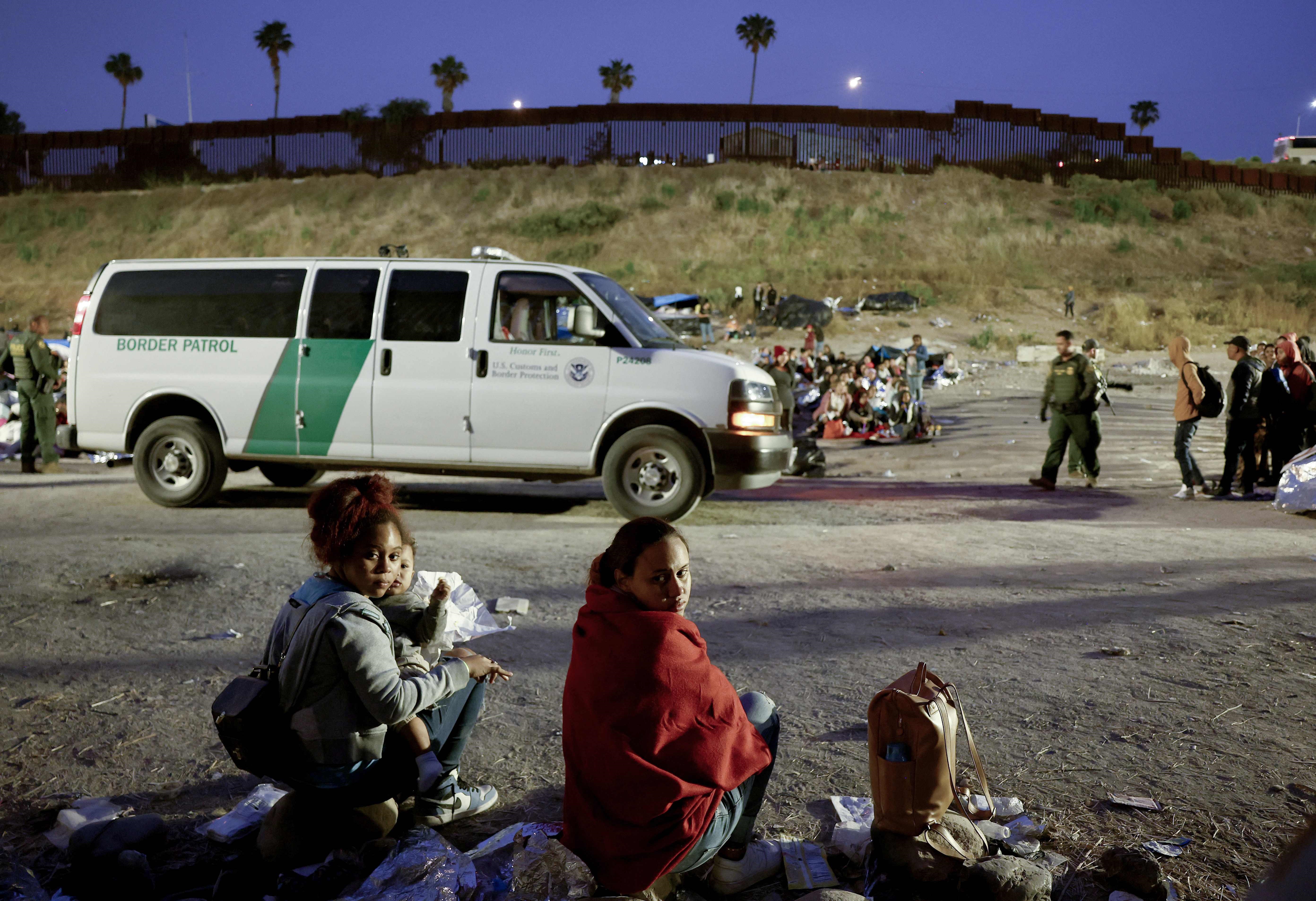 Dos mujeres y sus hijos se entregan a oficiales de la Patrulla Fronteriza en un área de San Diego California, donde pedirán asilo. (Foto Prensa Libre: AFP)