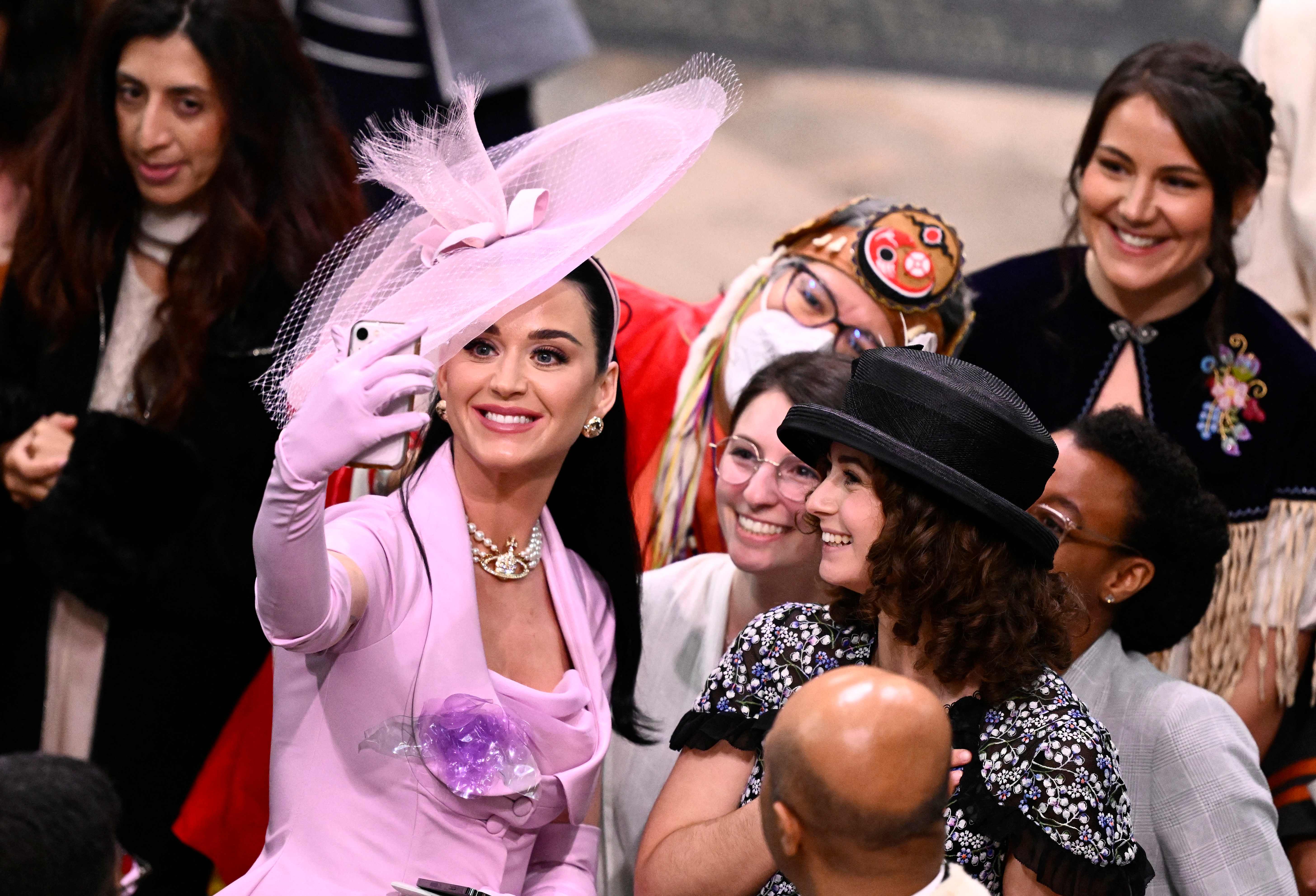 La cantautora estadounidense Katy Perry se toma selfies con invitados en la Abadía de Westminster en el centro de Londres el 6 de mayo de 2023,  (Foto Prensa Libre: AFP)