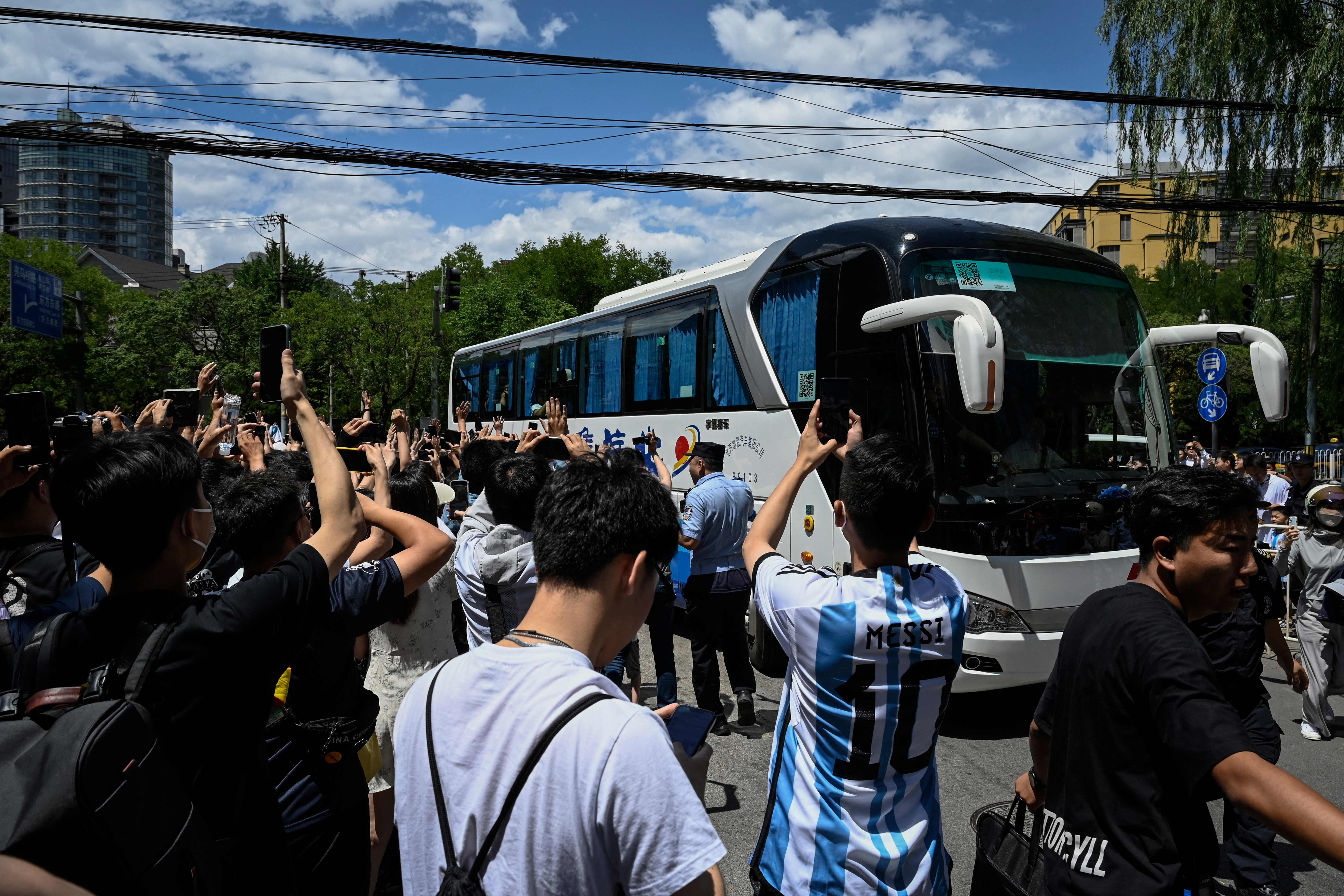 Chinese fans cheer as members of Argentina's football team arrive at a hotel in Beijing on June 10, 2023. Argentina will play a friendly football match against Australia on June 15 at Beijing's newly-renovated 68,000-capacity Workers' Stadium. (Photo by Jade GAO / AFP)