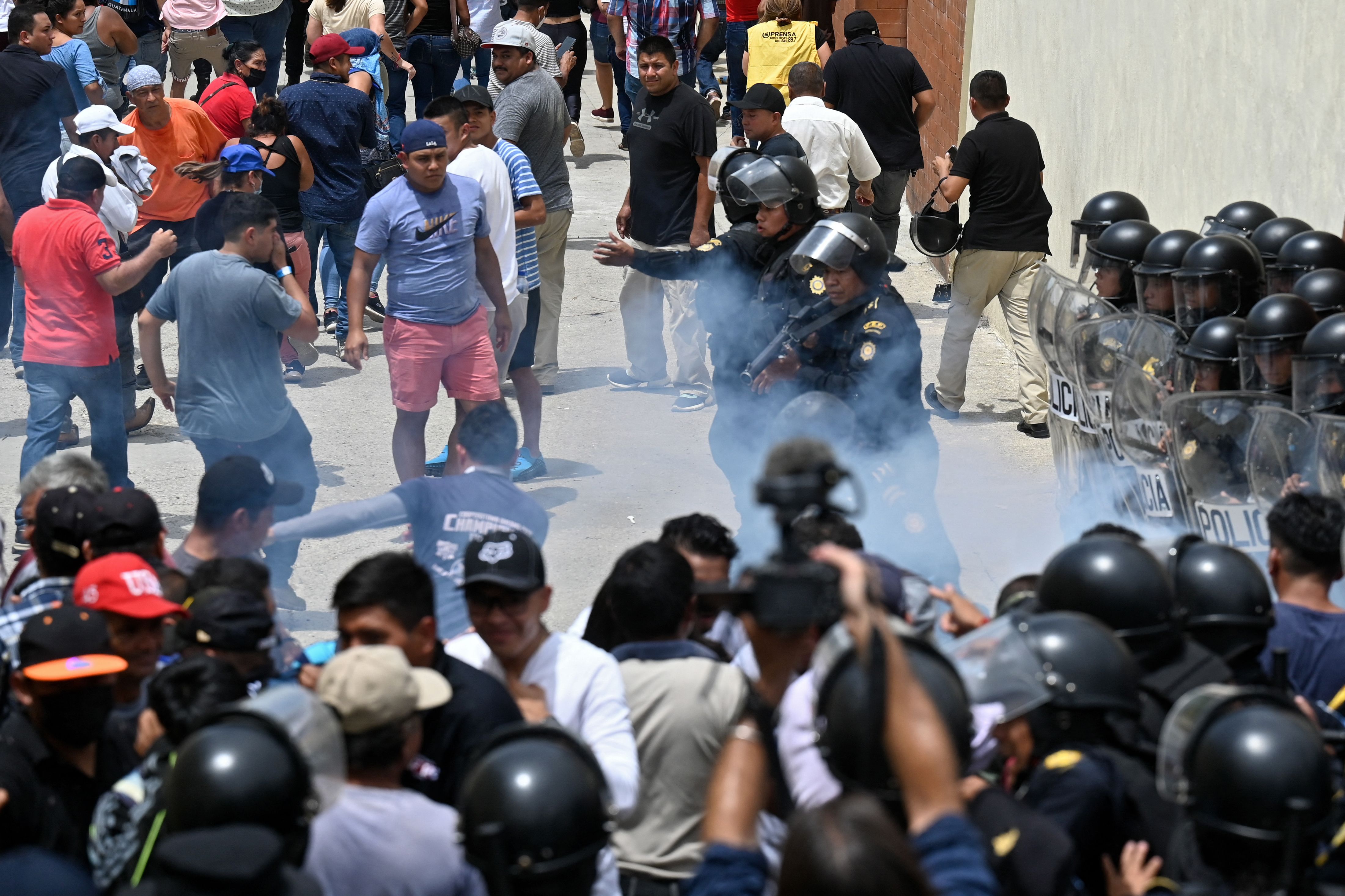 Agentes disparan gases lacrimógenos para dispersar a votantes que protestaban frente a un centro de votación  en San José del Golfo. (Foto Prensa Libre: AFP)