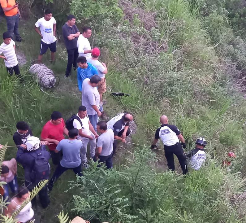 Bomberos Voluntarios y pobladores apoyaron en las tareas de rescate de personas que cayeron dentro de un vehículo en un barranco tras ser impactados por un tráiler. (Foto Prensa Libre: Bomberos Voluntarios).