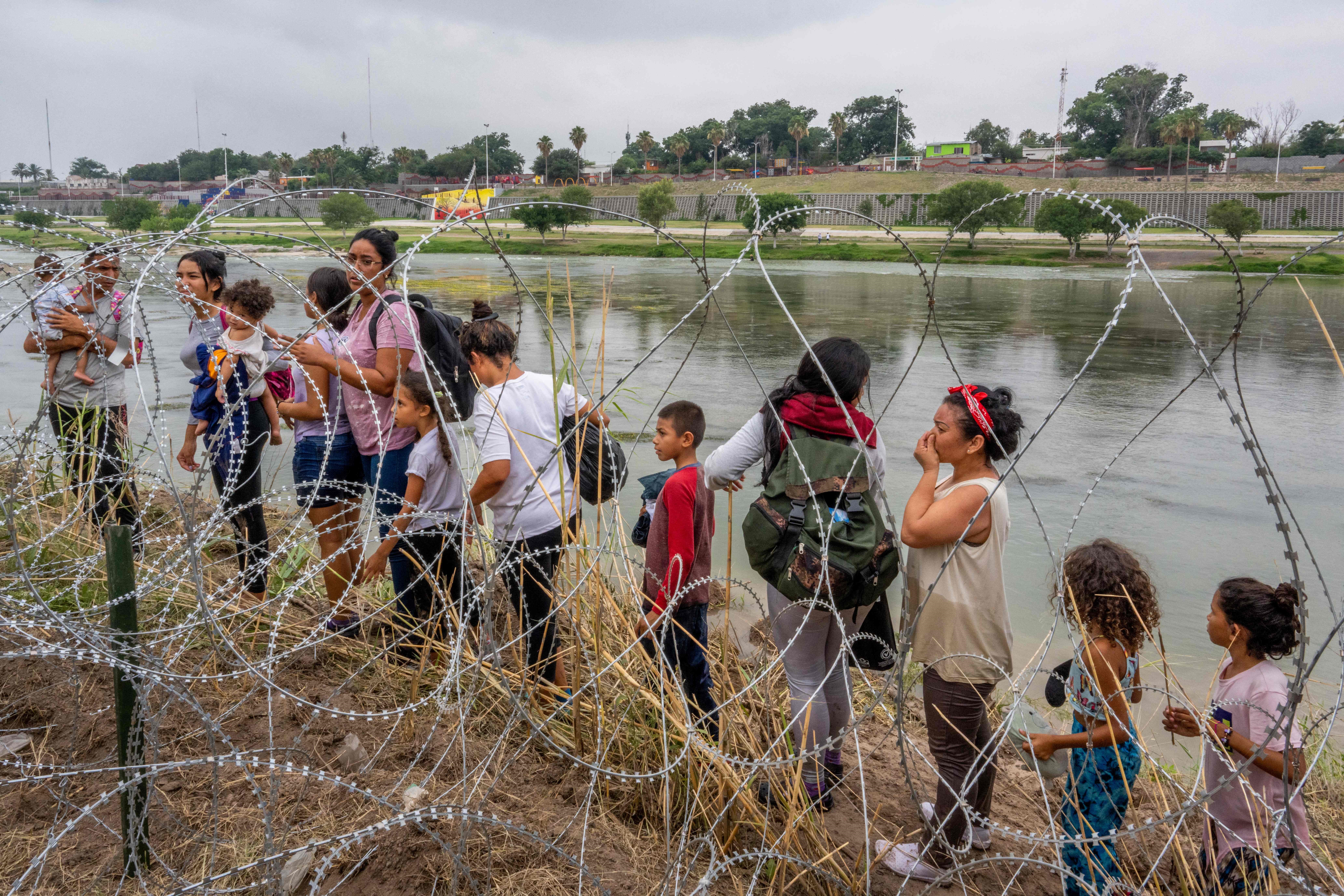 Migrantes en Eagle Pass, Texas, tratan de cruzar los alambres espigados para ingresar a territorio estadounidense y solicitar asilo. (Foto Prensa Libre: AFP)