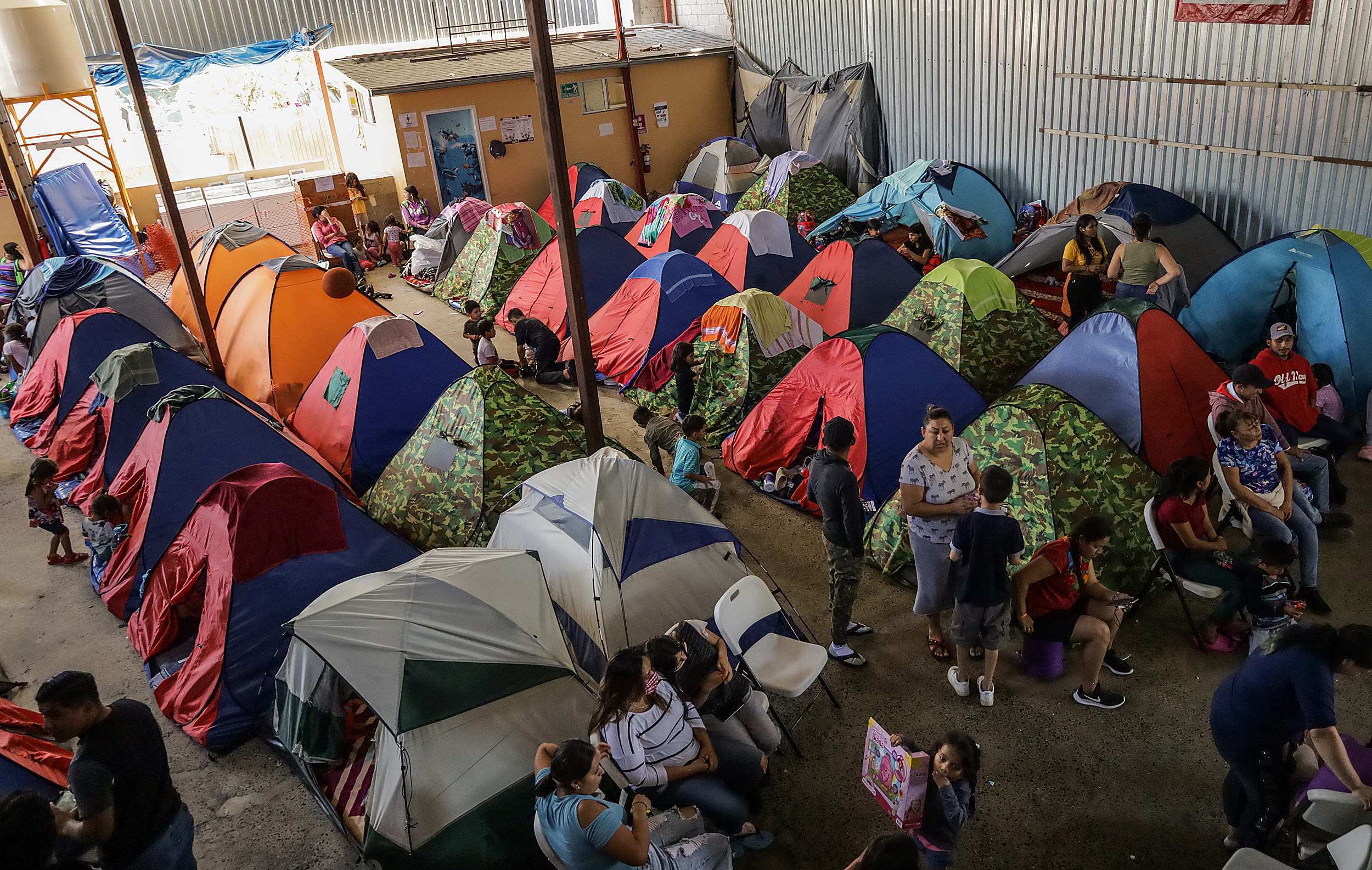 Migrantes permanecen en el albergue Movimiento Juventud 2000, el 24 de julio de 2023, en Tijuana, México). Pese a los crecientes riesgos en la frontera entre México y Estados Unidos, organizaciones civiles alertan porque aumentan los casos de migrantes desesperados, sobre todo familias, que cruzan ante las fallas de la aplicación CBP One para solicitar asilo a las autoridades estadounidenses. (Foto Prensa Libre: EFE)