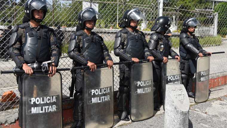 Efectivos policiales y militares resguardan el centro de operaciones del TSE, en el Parque de lndustria, donde se encuentran las cajas electorales. (Foto Prensa Libre: AFP)