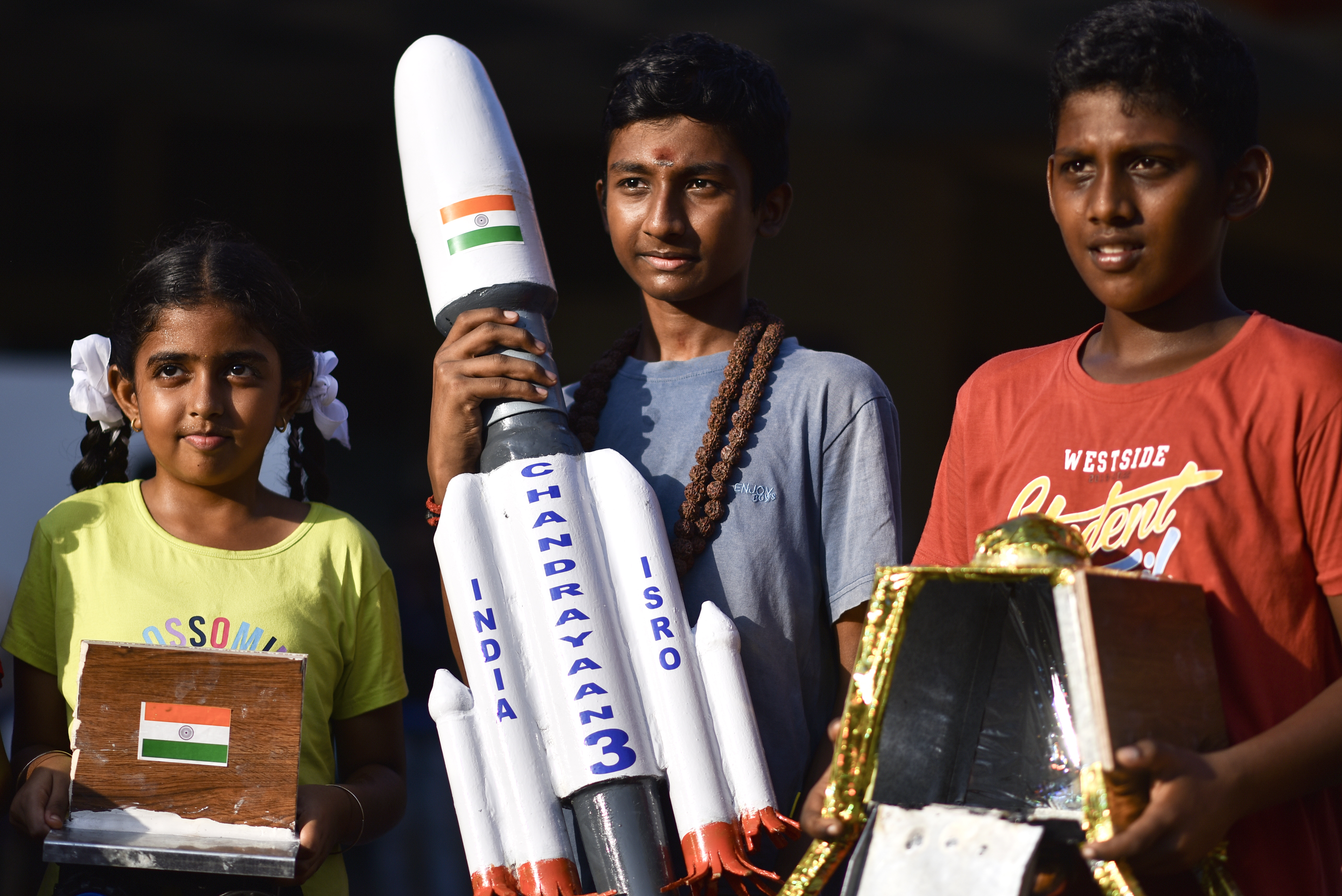 Niños muestran una réplica de la misión Chandrayaan-3 durante transmisión de su aterrizaje en el polo sur de la Luna. (Foto Prensa Libre: EFE/EPA/IDREES MOHAMMED)