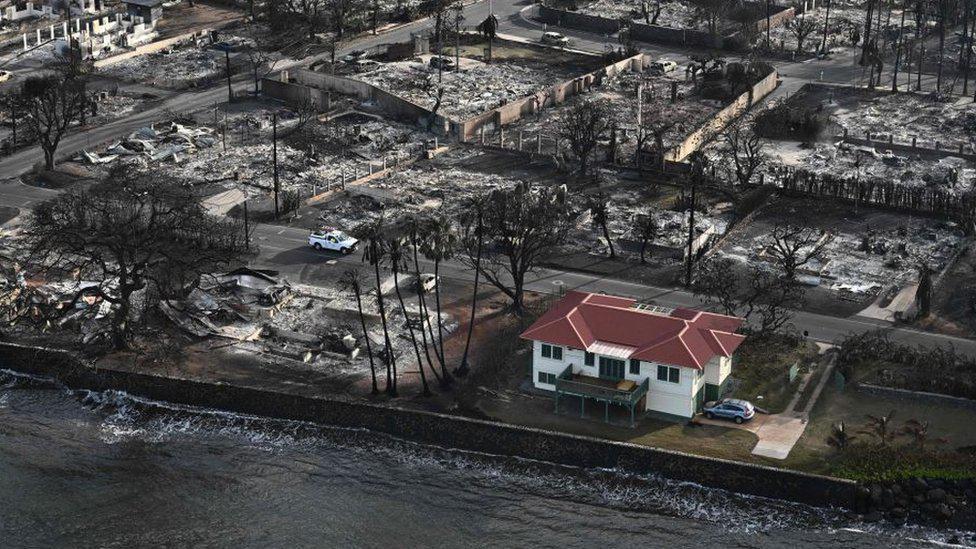 La casa de techo rojo quedó a salvo de los incendios en Lahaina, mientras que el resto del vecindario quedó reducido a escombros.