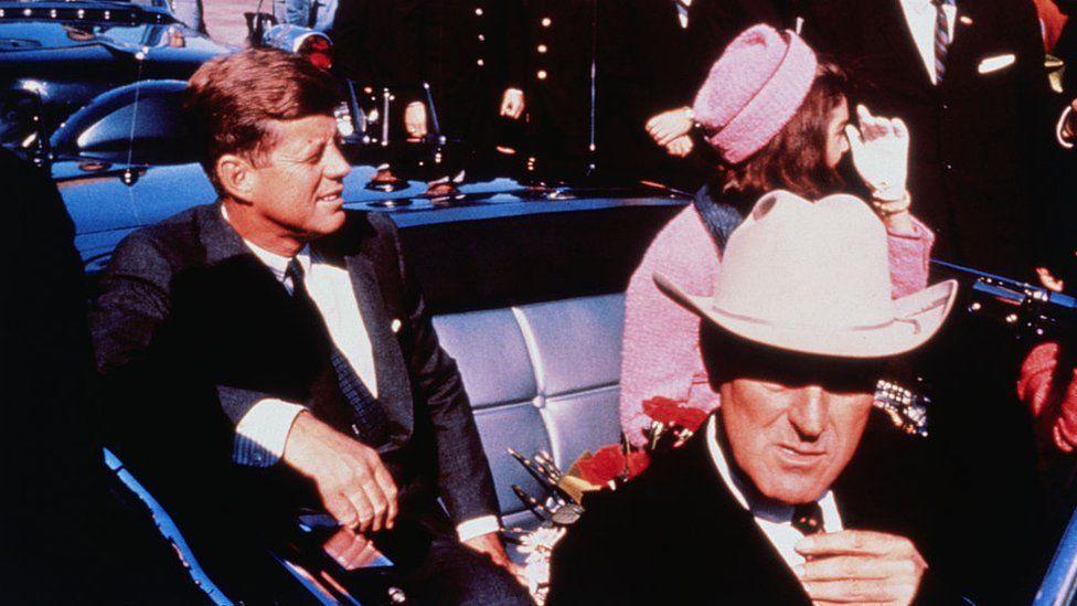 El gobernador de Texas, John Connally,  en primer plano, y John F. Kennedy y Jackie Kennedy en el asiento trasero.