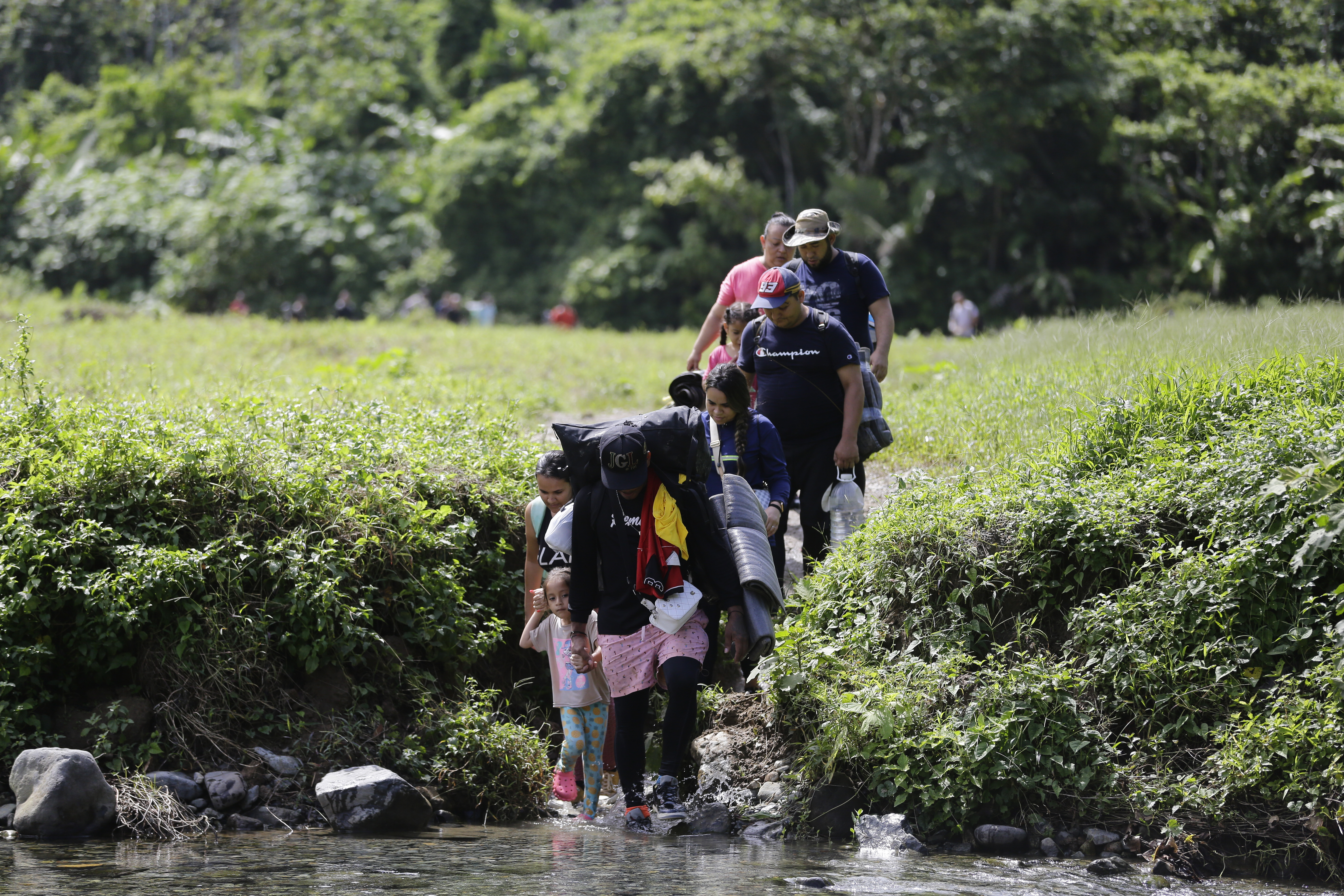Fotografía de archivo del 18 de agosto de 2023 donde aparecen migrantes acompañados con niños pequeños mientras caminan en el sector de Cañas Blancas en Darién, Panamá. (Foto Prensa Libre: EFE)