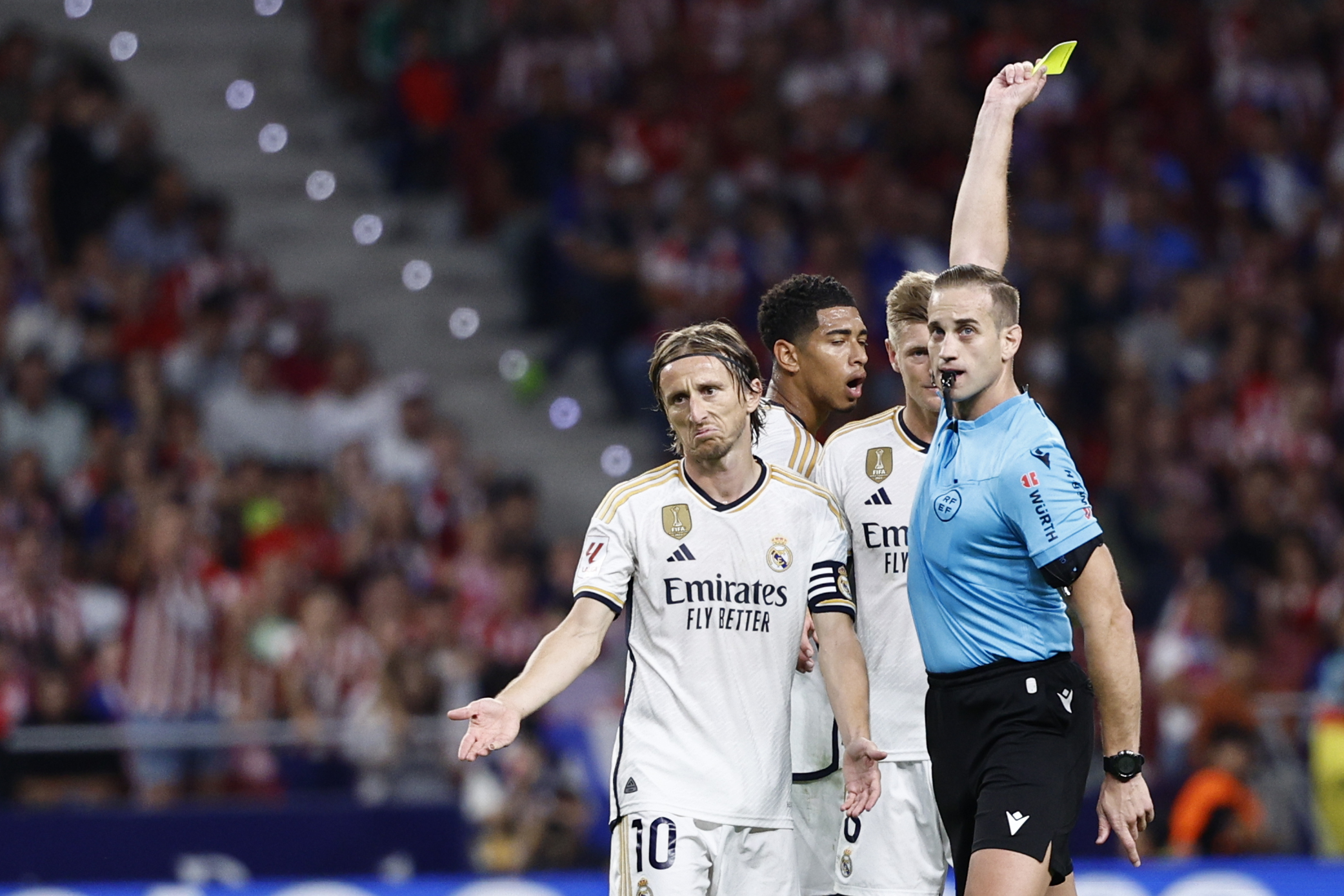 El centrocampista croata del Real Madrid, Luka Modric (i), protesta una decisión arbitral por la que ve la cartulina amarilla durante el partido ante el Atlético Madrid en el Cívitas Metropolitano. (Foto Prensa Libre: EFE)