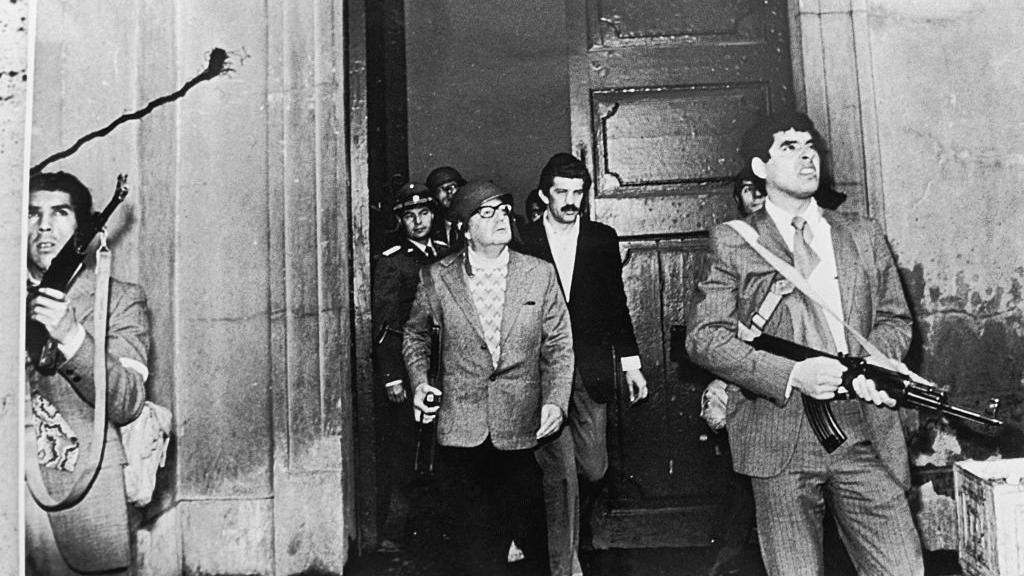Una de las imágenes que más impactó al mundo el 11 de septiembre de 1973: Salvador Allende con fusil en mano y casco, en medio del ataque a La Moneda. 
GETTY IMAGES

