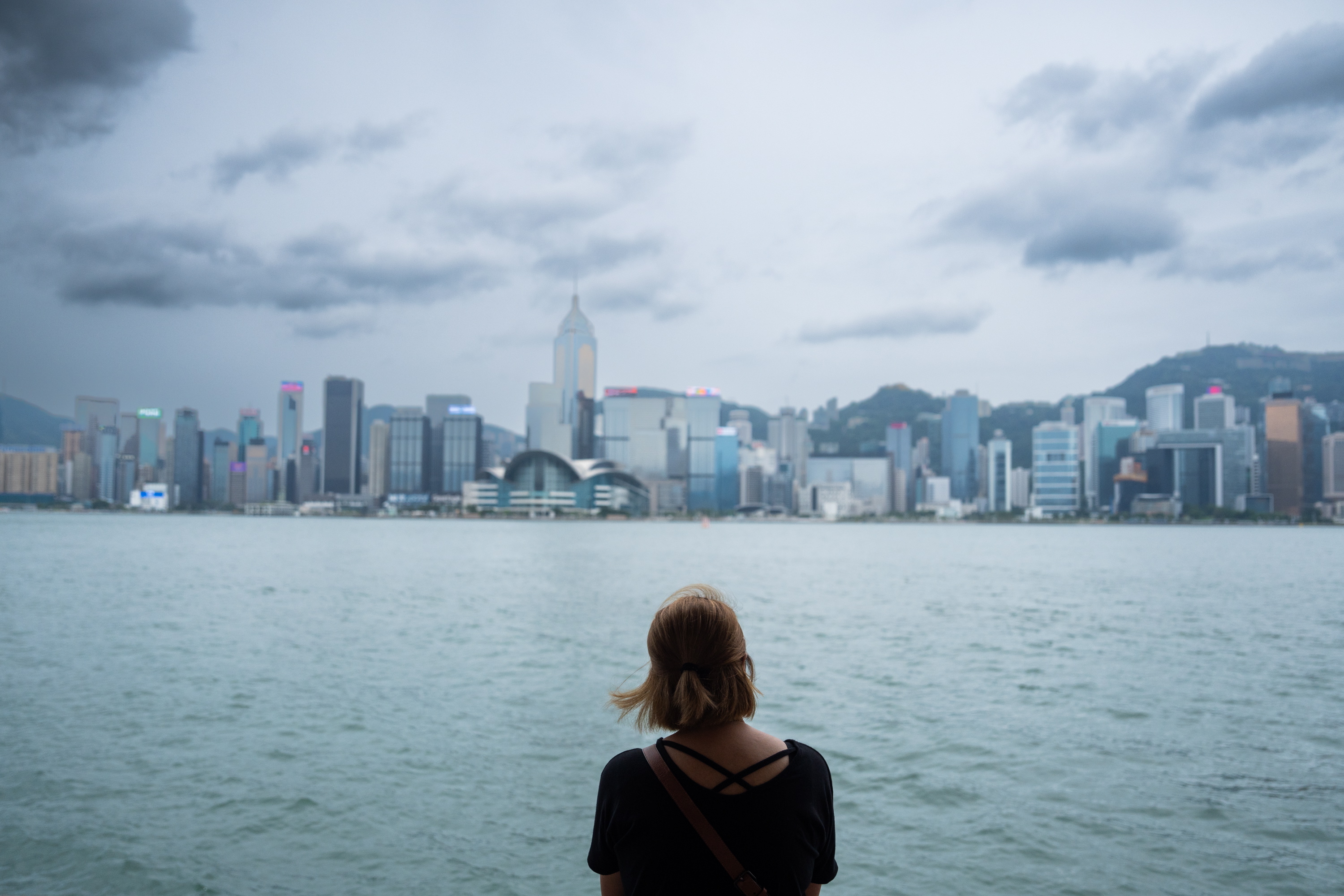 Una mujer observa el perfil urbano de Hong Kong mientras se aproxima el tifón Saola. (Foto Prensa Libre: EFE/ Bertha Wang)