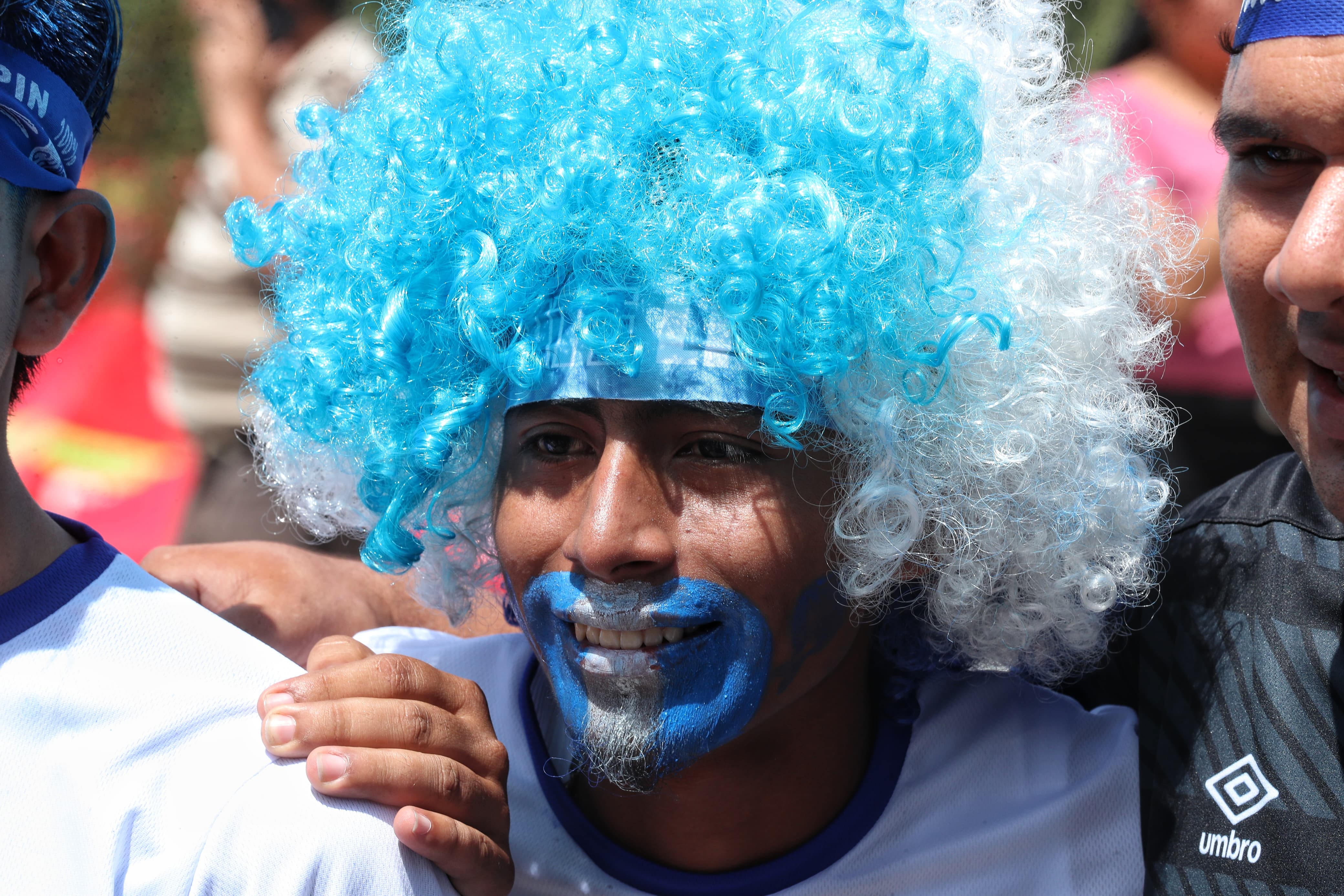 Persona lleva peluca con los colores de la bandera de Guatemala'