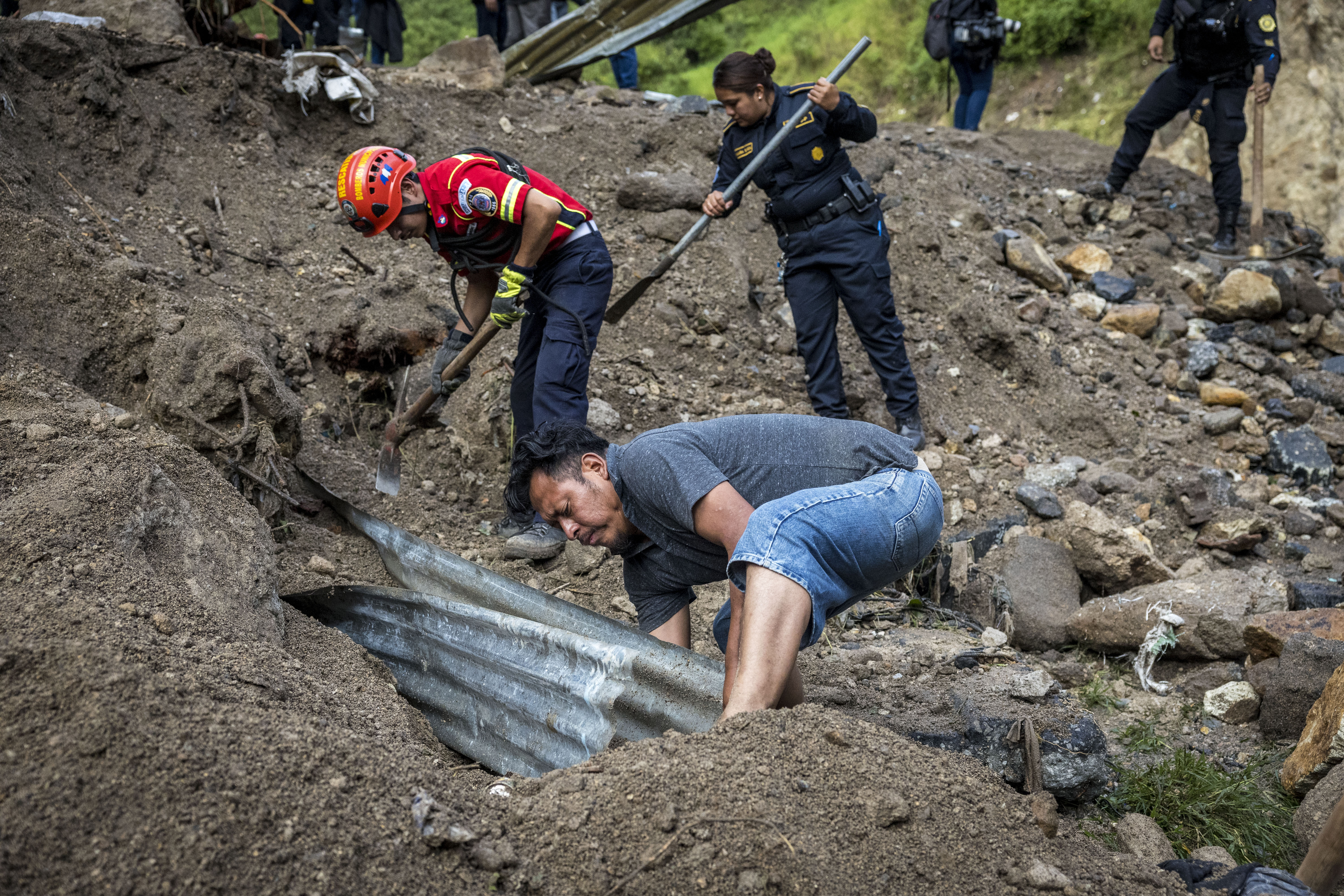 Rescatistas, policías y familiares de las víctimas buscan los cuerpos de las personas enterradas por el río El Naranjo, en el asentamiento Dios es Fiel, zona 7 de la Ciudad de Guatemala. (Foto Prensa Libre: EFE)
