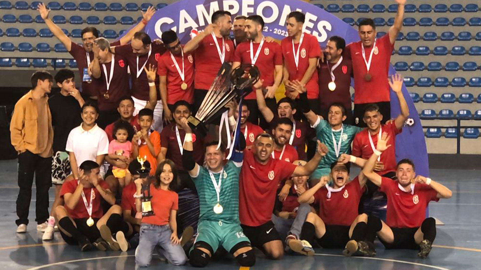 El equipo de Glucosoral sobre la duela del domo zona 13, festejando su decimotercer título del futsal nacional. (Foto Prensa Libre: cortesía)
