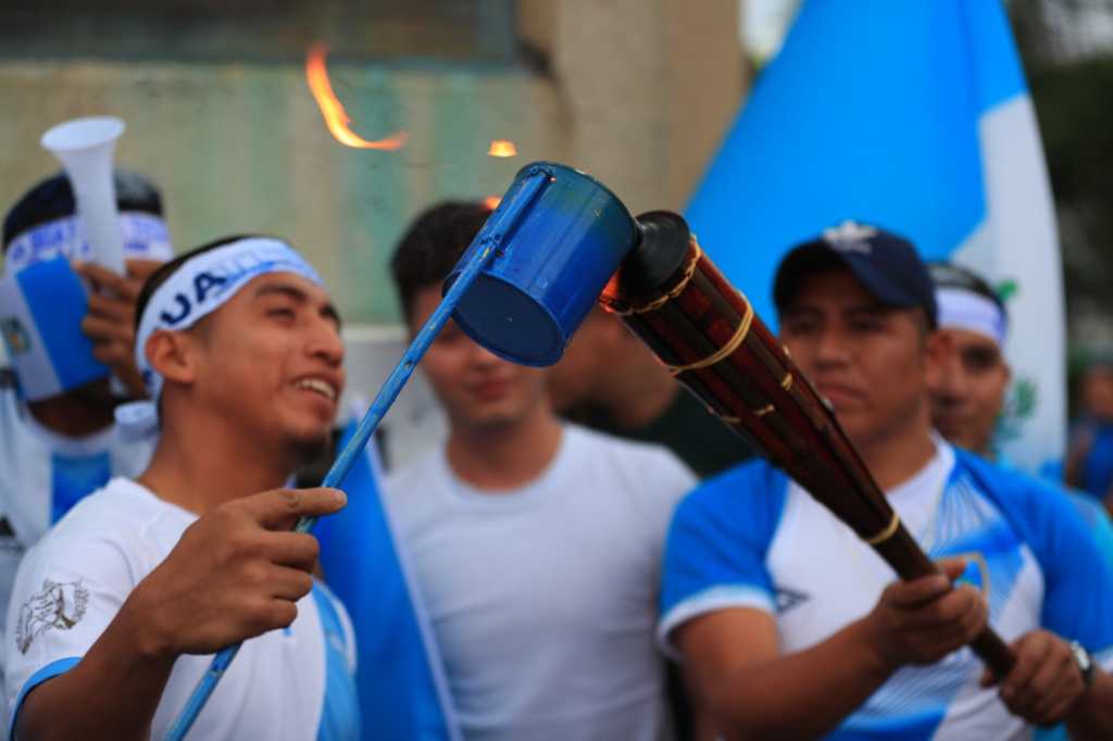 guatemaltecos encendiendo una antorcha en la plaza del obelisco