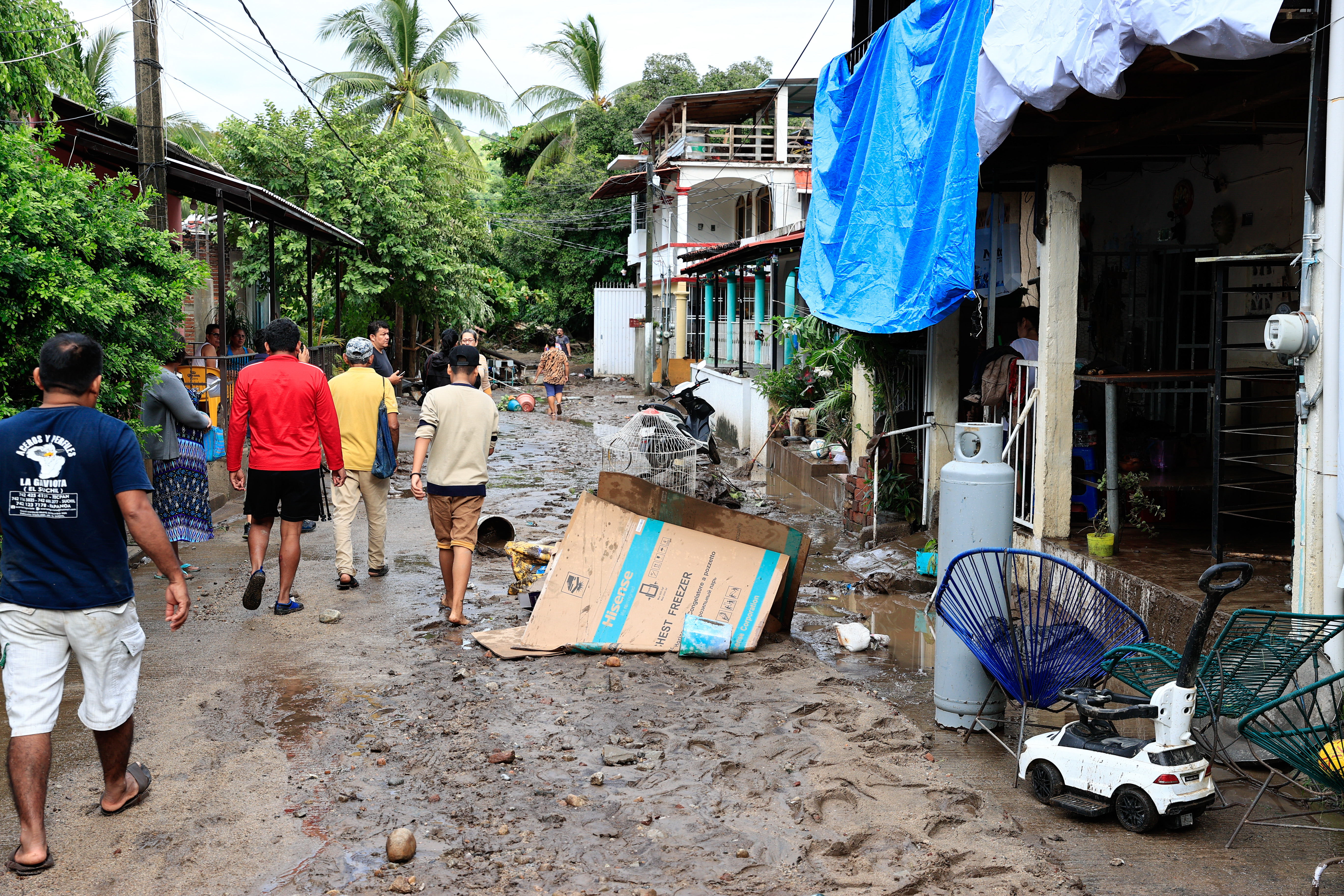 Personas caminan en medio de los daños debido al paso de la tormenta Max y el huracán Lidia.  (Foto Prensa Libre: EFE/David Guzmán)