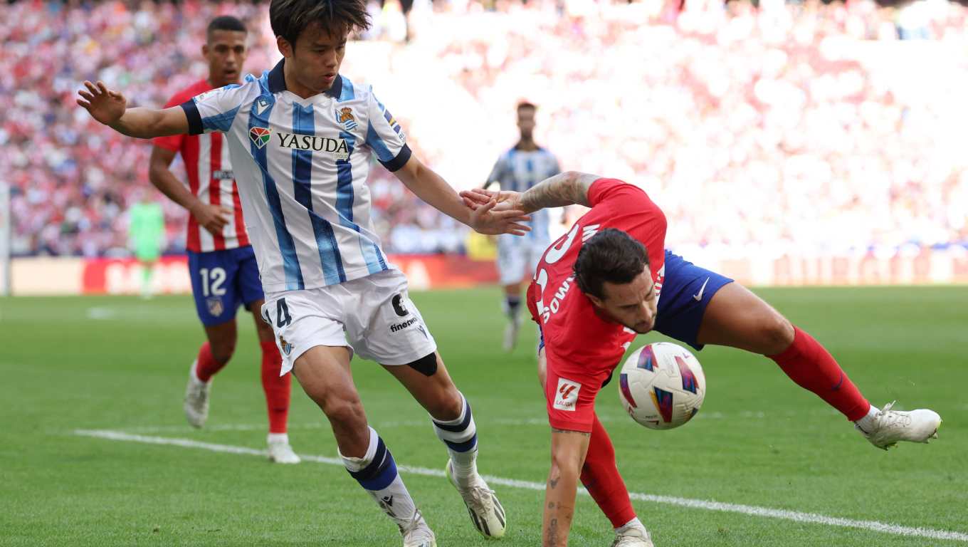 El jugador de la Real Sociedad, Takefusa Kubo, choca con el defensa del Atlético, Mario Hermoso.(Foto Prensa Libre: AFP)