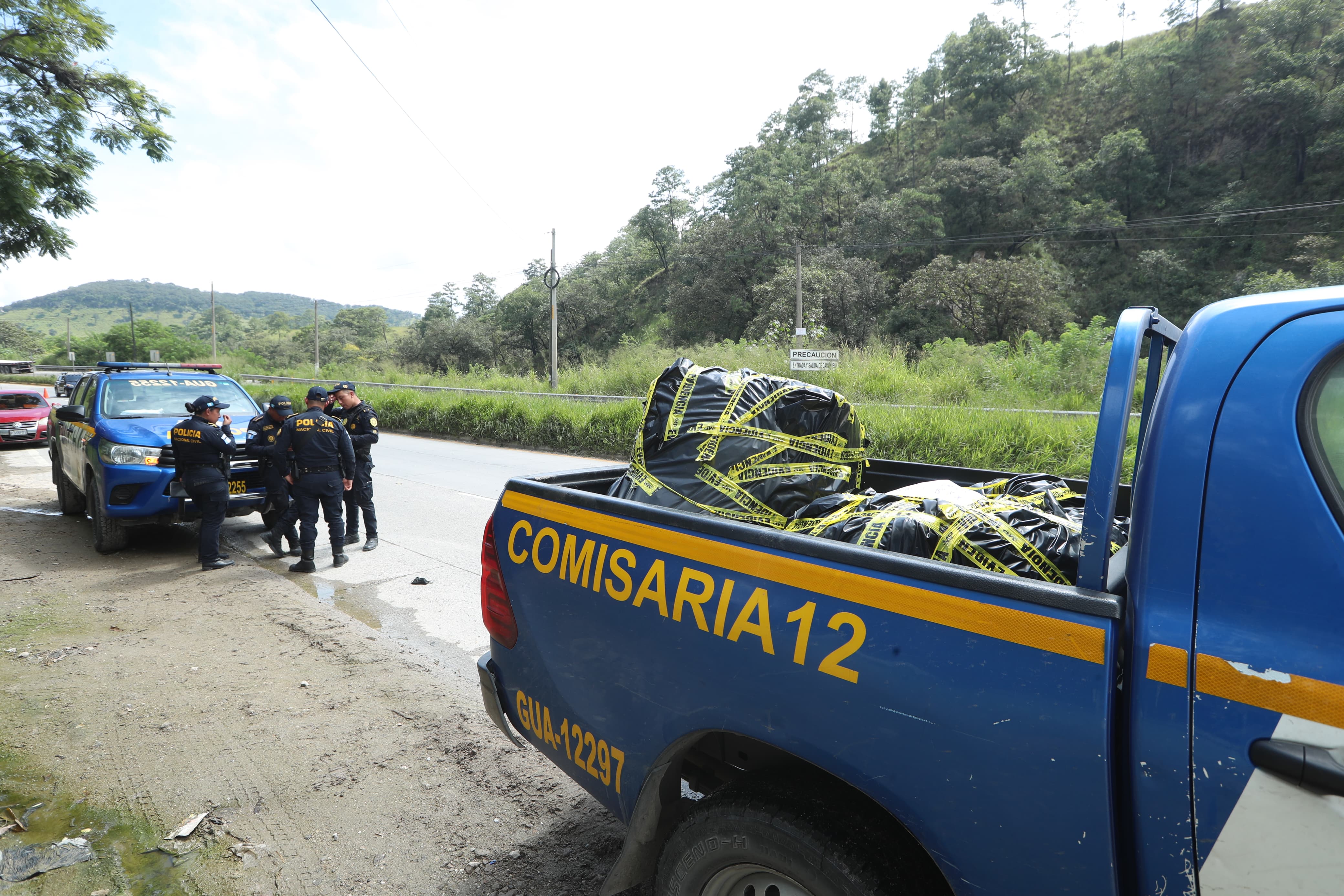 Los cadáveres de tres personas fueron localizados a la orilla de la carretera en el km 21 de la ruta al Atlántico. (Foto Prensa Libre: Esbin García)