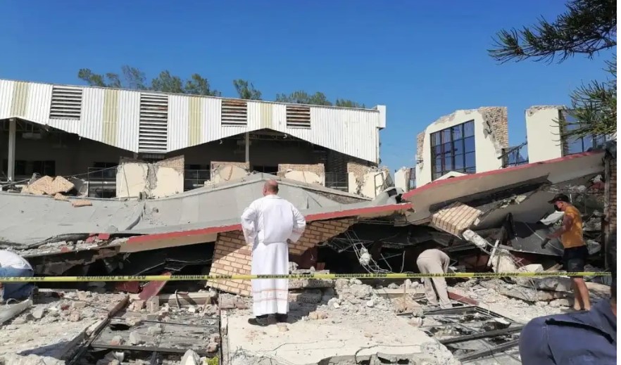 Un sacerdote observa los escombros tras el desplome de techo en templo católico. (Foto Prensa Libre: AFP)