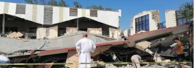 Un sacerdote observa los escombros tras el desplome de techo en templo católico. (Foto Prensa Libre: AFP)