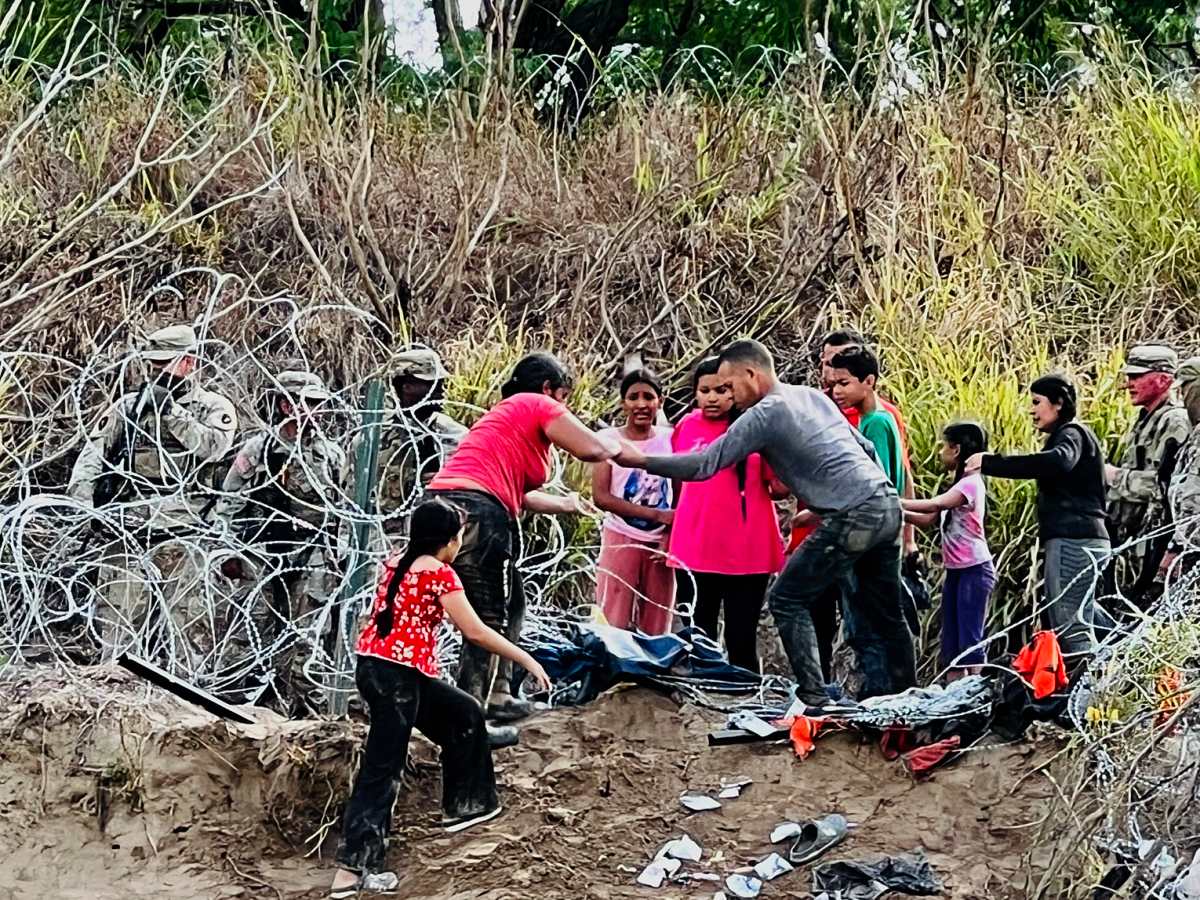 Un grupo de más de 50 migrantes entró por la fuerza desde México a Estados Unidos este martes tras derribar a elementos de la Guardia Nacional estadounidense y la alambrada de púas que colocó el Gobierno de Texas en el río Bravo. (Foto Prensa Libre: EFE/Abraham Pineda)