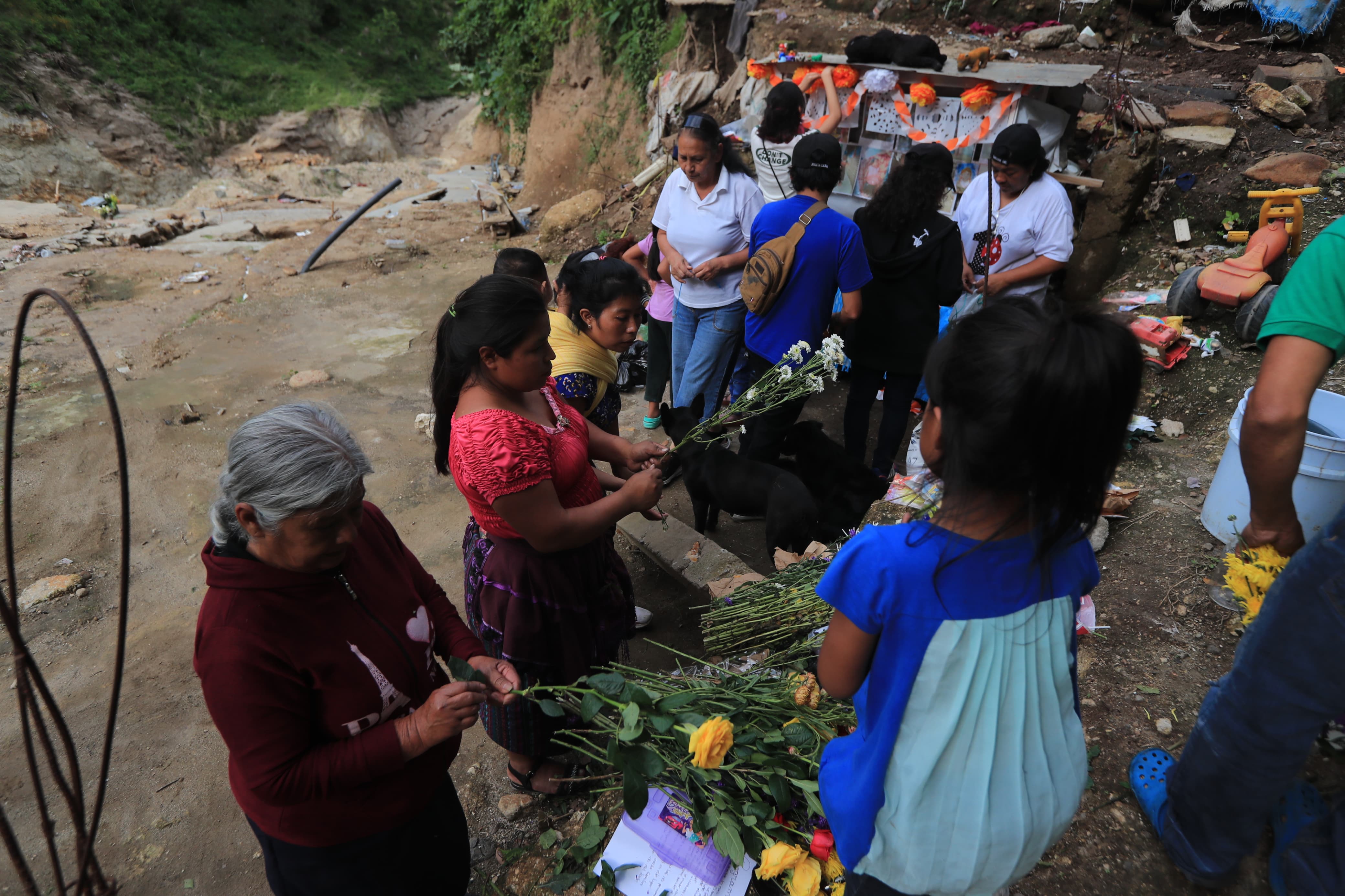 Personas llevan flores al altar en homenaje a las víctimas de la tragedia en El Naranjo'