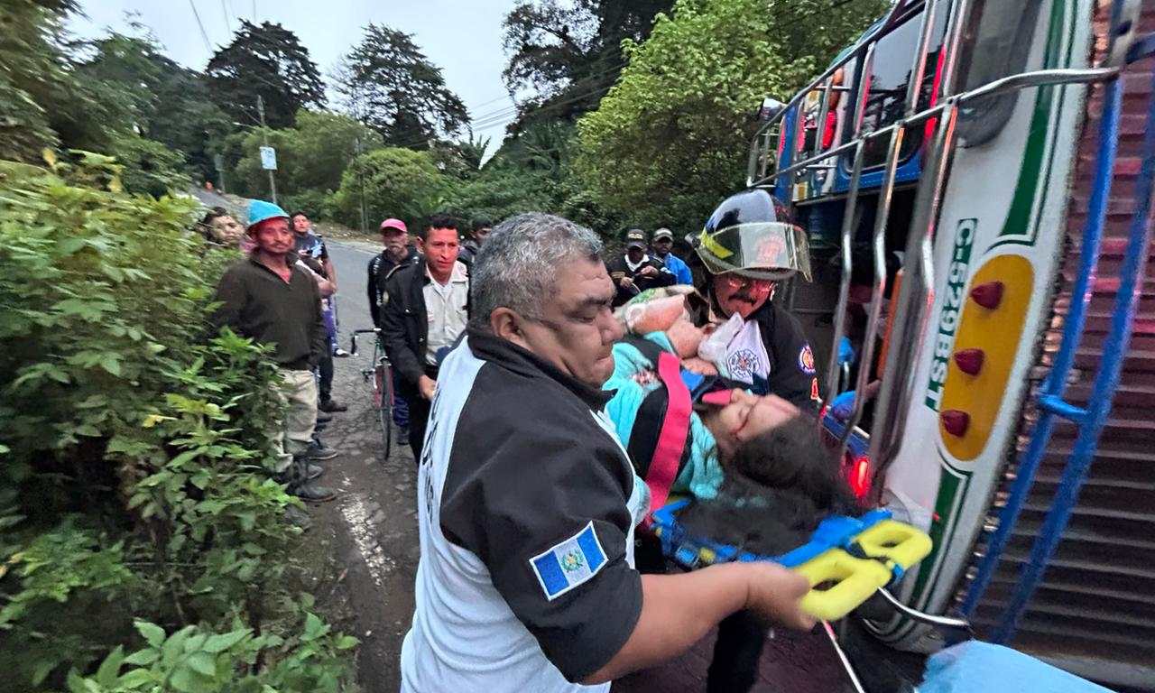 Socorristas trasladan a uno de los heridos del accidente en km 24 de la ruta a residenciales San José, en San José Pinula, en donde un bus volcó. (Foto Prensa Libre: Bomberos Voluntarios)
