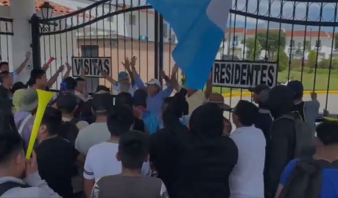 Grupo de manifestantes intenta ingresar al condominio en donde supuestamente vive la fiscal Consuelo Porras, en zona 4 de Mixco. (Foto Prensa Libre: Captura de video)