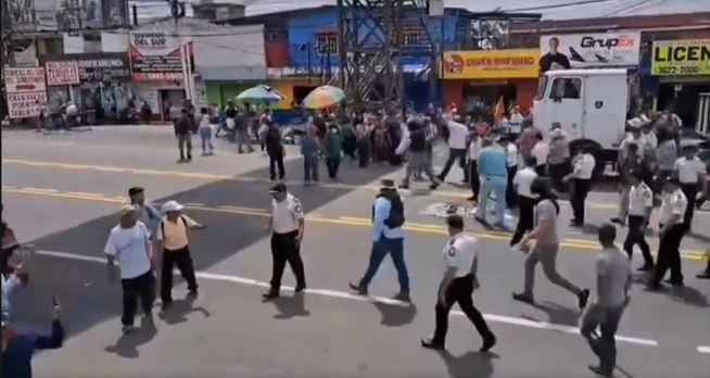 Grupo de hombres armados retira a los manifestantes del bloqueo ubicado en Mazatenango, Suchitepéquez, ante la mirada de la PNC. (Foto Prensa Libre: captura de video Sn José L Ídolo Noti)