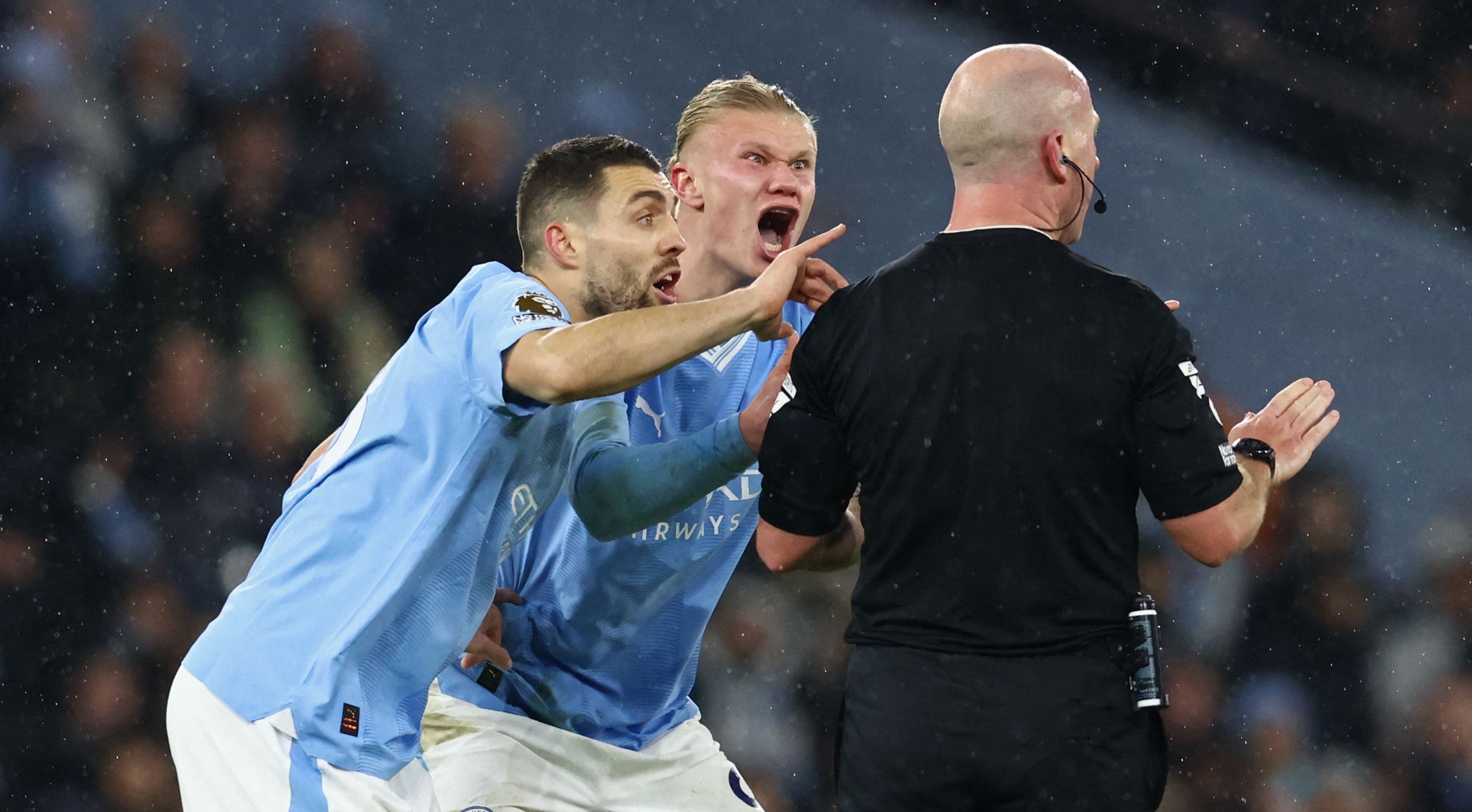 Los jugadores del Manchester City, Mateo Kovacic (i) y Erling Haaland, le reclaman al árbitro, Simon Hooper.(Foto Prensa Libre: AFP) 