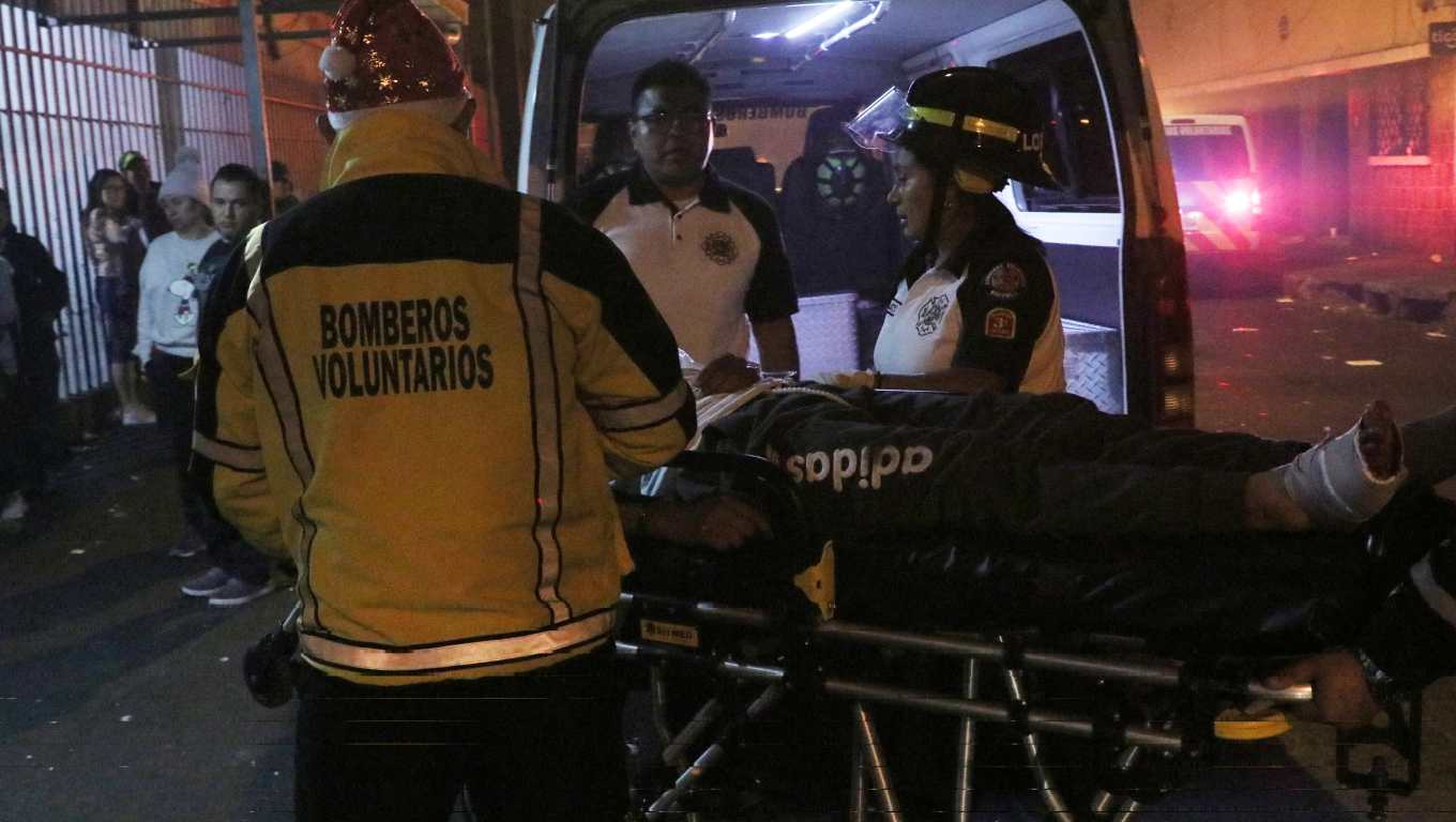 Socorristas trasladan a un centro asistencial a un hombre alcanzado por balas perdidas. (Foto Prensa Libre: Bomberos Voluntarios)