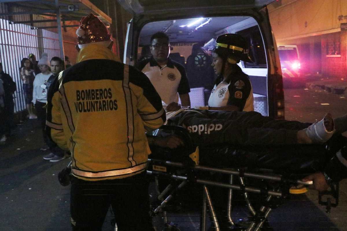 Socorristas trasladan a un centro asistencial a un hombre alcanzado por balas perdidas. (Foto Prensa Libre: Bomberos Voluntarios)