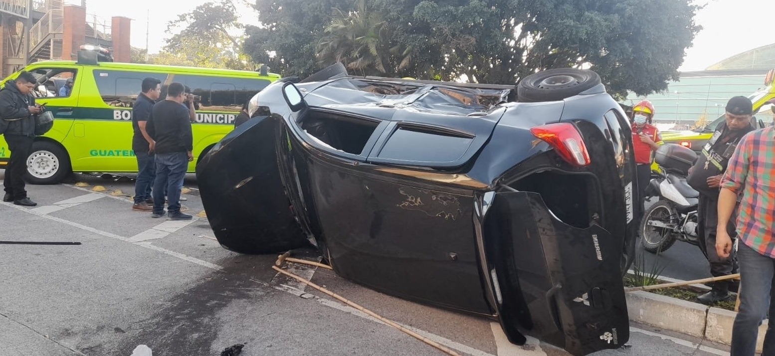 Se desconocen las causas del choque entre un taxi y un carro que quedó volcado en medio de la calle en El Naranjo. (Foto Prensa Libre: Bomberos Municipales)