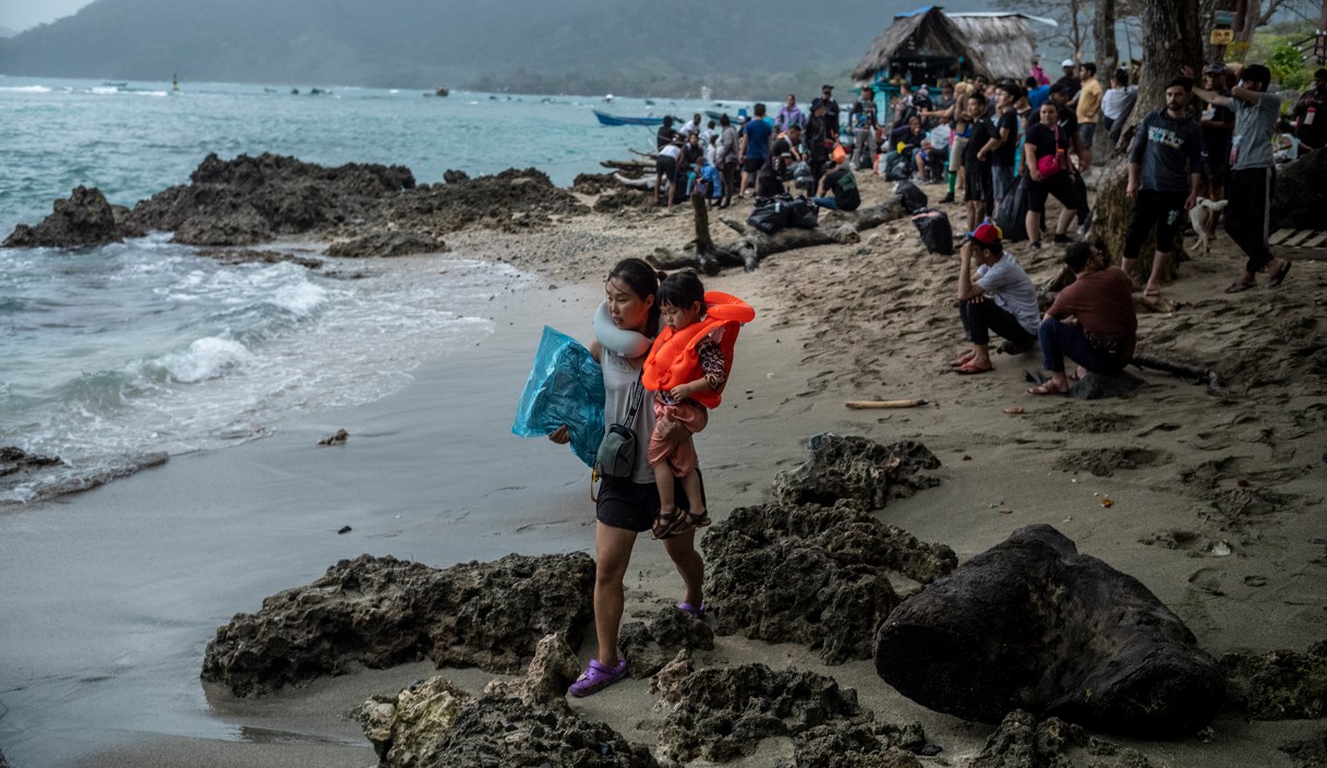 Migrantes chinos se disponen a cruzar el Tapón del Darién Capurgana, la última población de la frontera caribeña de Colombia antes de llegar a Panamá, el 2 de marzo de 2023. (Federico Rios/The New York Times)
