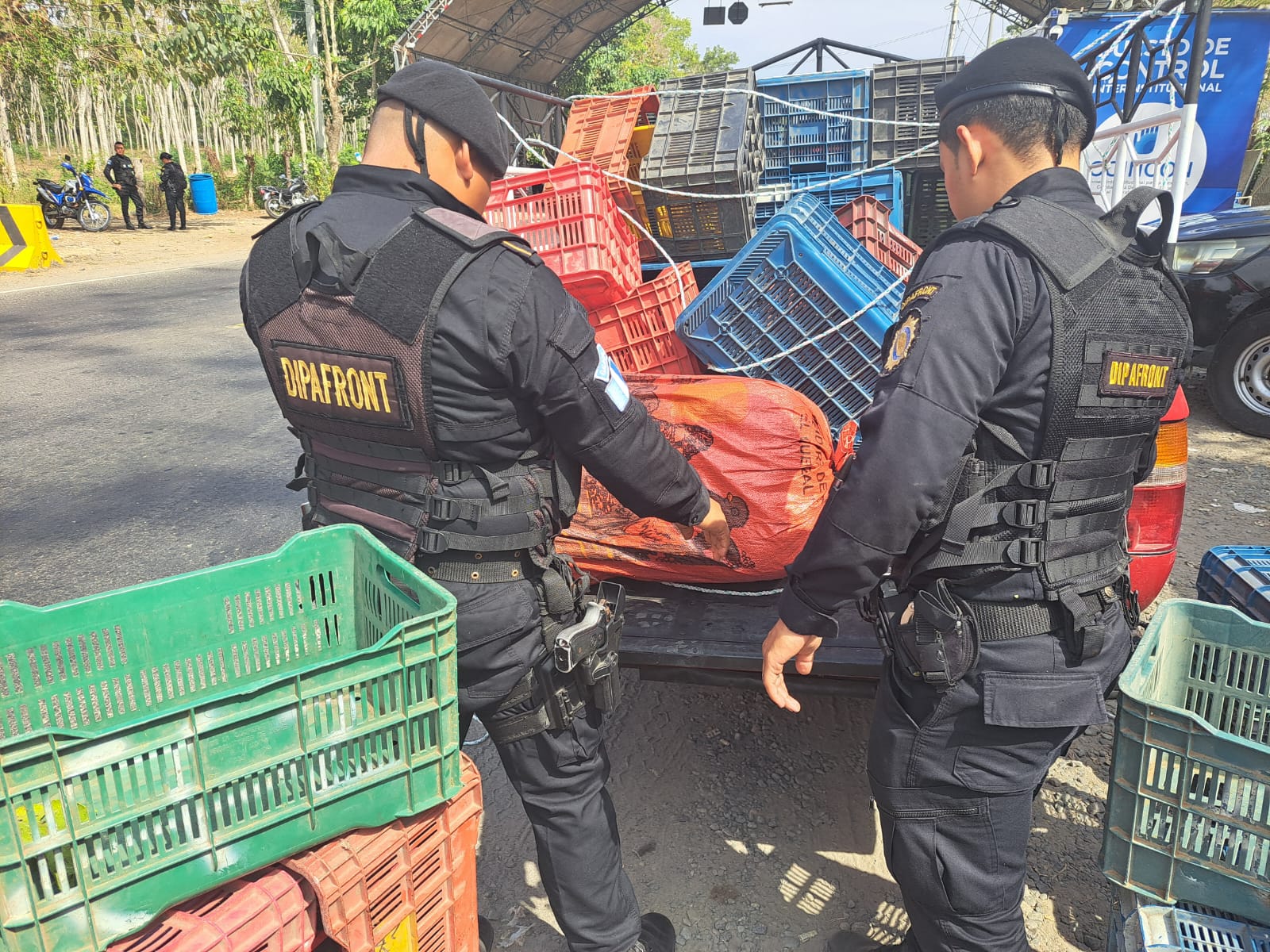 Agentes de la PNC revisan los costales que viajaban ocultos en un picop. (Foto Prensa Libre: PNC)
