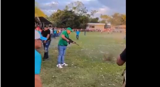 Un hombre usa un arma larga durante la final del campeonato navideño de futbol de la aldea El Rico, Los Amates, Izabal. Las autoridades dicen que investigan el hecho. (Foto Prensa Libre: Captura de pantalla).