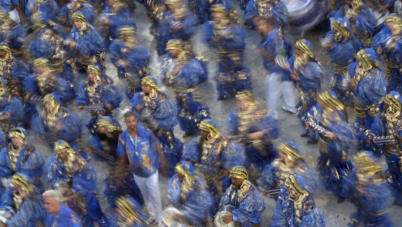Unas 70 mil personas ondearon banderas, cantaron y danzaron en las gradas durante horas, llegando al éxtasis cuando aparecía la "escola" de sus amores, durante la segunda noche del festival. (Fotografía Prensa Libre: AFP) 
